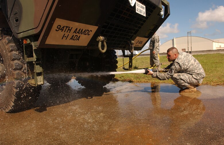 An Army soldier from the 1-1 Air Defense Artillery Brigade washes a Hemmet along with the Patriot Advanced Capability missile equipment at Kadena Air Base, Japan, July 11, 2007. The 1-1 ADA stored their most valuable equipment in a hangar near the flightline in preparation for Typhoon Man-Yi, the first typhoon of the year for Okinawa. Before having them stored, both the equipment and vehicle are washed at Papa ramp to prevent foreign object damage.  U.S. Air Force photo/Staff Sgt. Reynaldo Ramon

