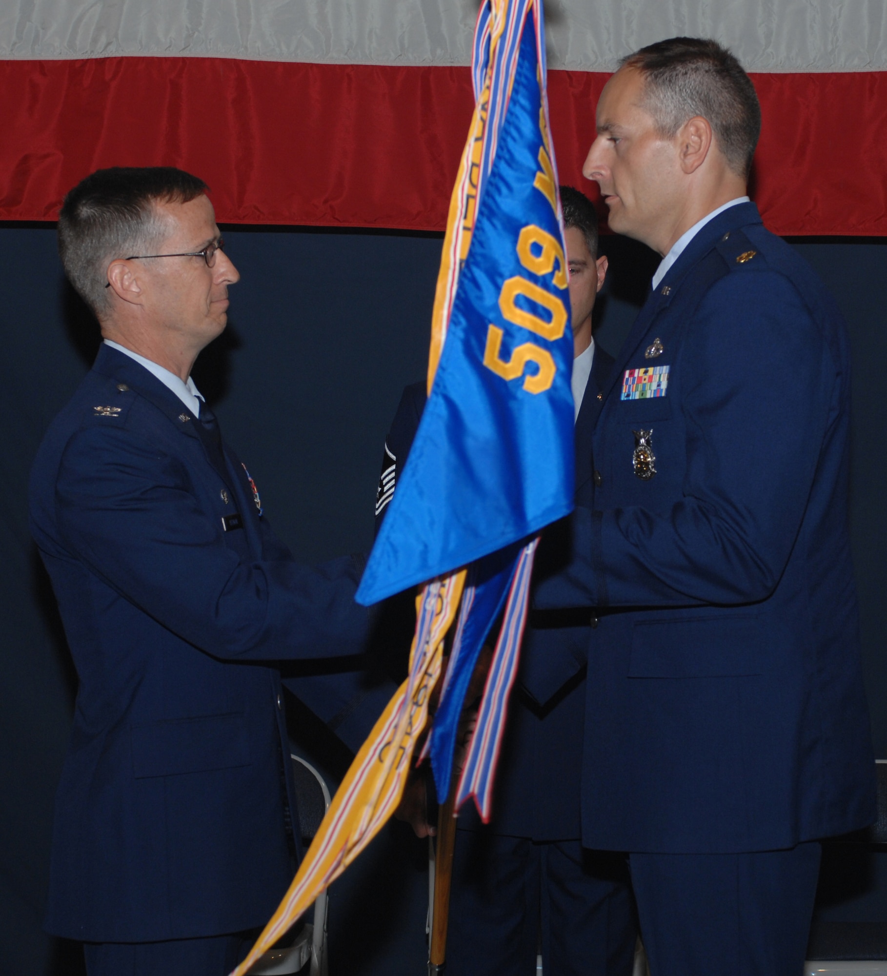 Col. Ed Keegan, 509th Mission Support Group commander, passes the guidon of the 509th Civil Engineer Squadron to Maj. Craig Johnson during a change-of-command ceremony June 27. Major Johnson was previously the commander of the 355th CES operations flight, Davis-Monthan Air Force Base, Ariz. Lt. Col. Pamela Moxely, the former 509th CES commander, moves on to Royal Air Force Mildenhall, U.K., and becomes the 100th Mission Support Group deputy commander. (U.S. Air Force photo/Airman 1st Class Cory Todd)