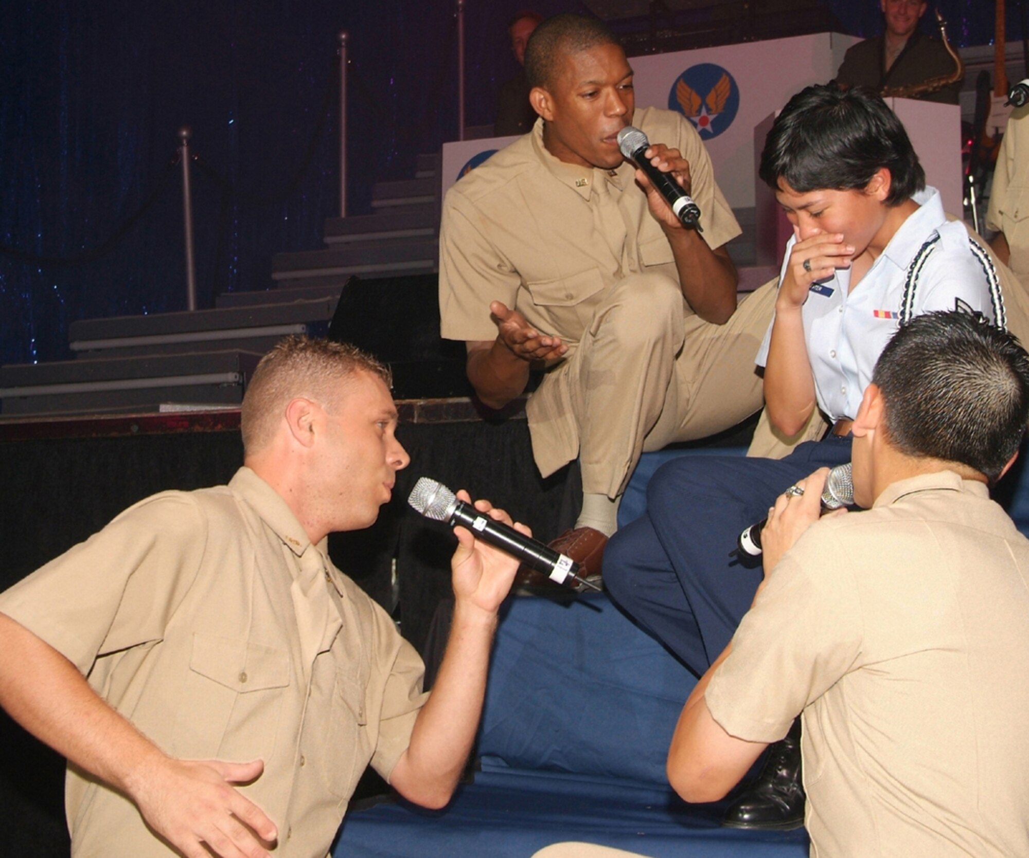 Airman Amari, left, Staff Sgt. Keith Loudermill and Senior Airman Rick Rosales serenade Airman 1st Class Stephanie Hunter on stage.  Airman Hunter is a student in the 336th Training Squadron.  Sergeant Loudermill is from Randolph AFB, Texas, and Airman Rosales is stationed at Osan Air Base, Republic of Korea.  (U.S. Air Force photo by Adam Bond)