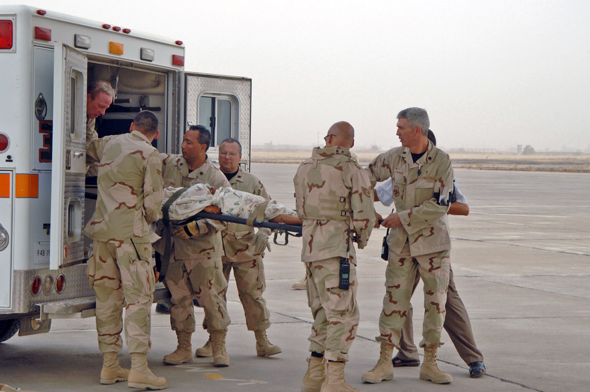 Members of the 506th Air Expeditionary Group help transport Iraqi vehicle borne improvised explosive device victims to a Turkish airplane during a multinational humanitarian airlift effort July 8 at Kirkuk Air Base, Iraq. The victims were hurt in the July 7 market bombing in Tuz Khurmato, Iraq. Airmen from the 506th AEG worked with Iraqi medical providers and Turkish army and air force members to receive, transfer and aerovac almost 30 injured Turkmen civilians and family members to the Turkish capital city of Ankara for further treatment. (U.S. Air Force photo/Senior Airman Kristin Ruleau)
