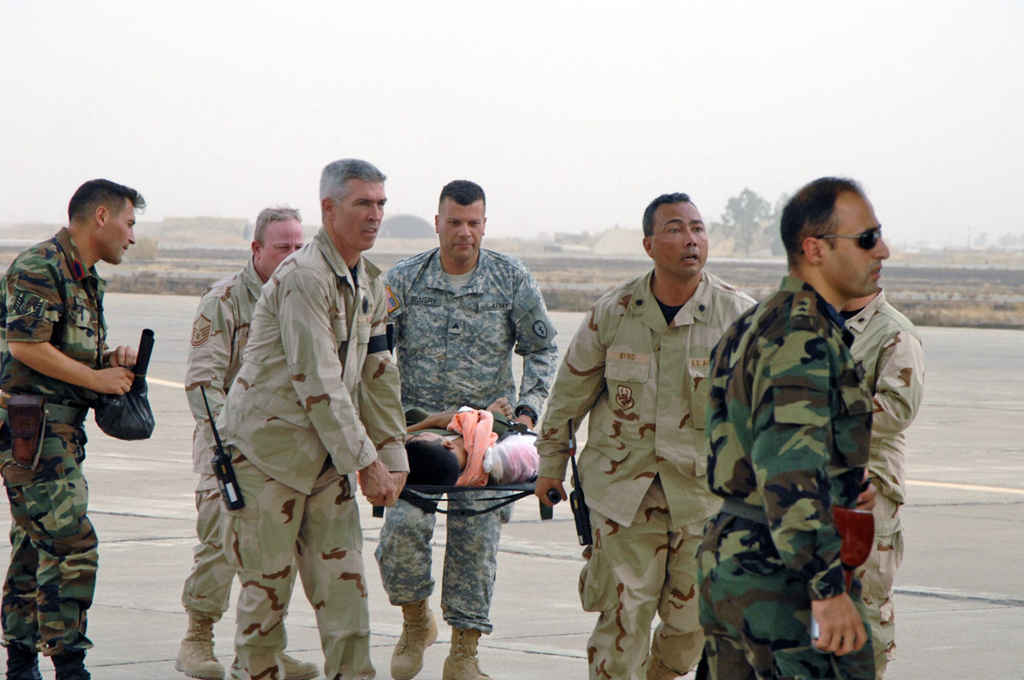 Lieutenant Colonels Gerald McManus (center left) and Richard Byrd, Master Sgt. Joseph Rose (center back left) and Army Sgt. Ramy Elmery (center) carry a vehicle borne improvised explosive device victim to a Turkish airplane July 8 at Kirkuk Air Base, Iraq. The victim was hurt in the July 7 market bombing in Tuz Khurmato, Iraq. Airmen from the 506th Air Expeditionary Group worked with Iraqi medical providers and Turkish army and air force members to receive, transfer and aerovac almost 30 injured Turkmen civilians and family members to the Turkish capital city of Ankara for further treatment. (U.S. Air Force photo/Senior Airman Kristin Ruleau) 
