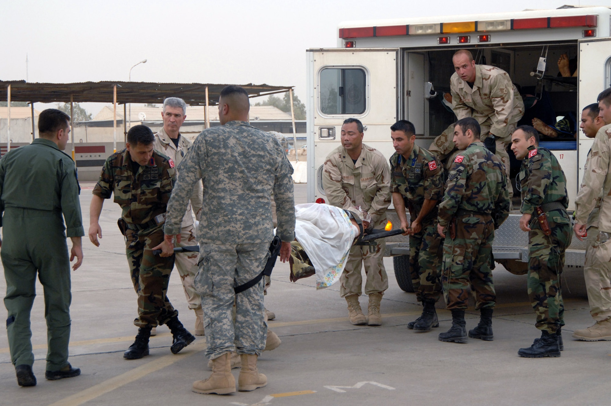 Airmen from the 506th Air Expeditionary Group, an Army Soldier and Turkish army and air force members help transport a victim of an Iraqi vehicle borne improvised explosive device to a Turkish medical aircraft July 8 at Kirkuk Air Base, Iraq. The victim was hurt in the July 7 market bombing in Tuz Khurmato, Iraq. Airmen from the 506 AEG worked with Iraqi medical providers and Turkish military members to receive, transfer and aerovac almost 30 injured Turkmen civilians and family members to the Turkish capital city of Ankara for further treatment. (U.S. Air Force photo/Senior Airman Kristin Ruleau)