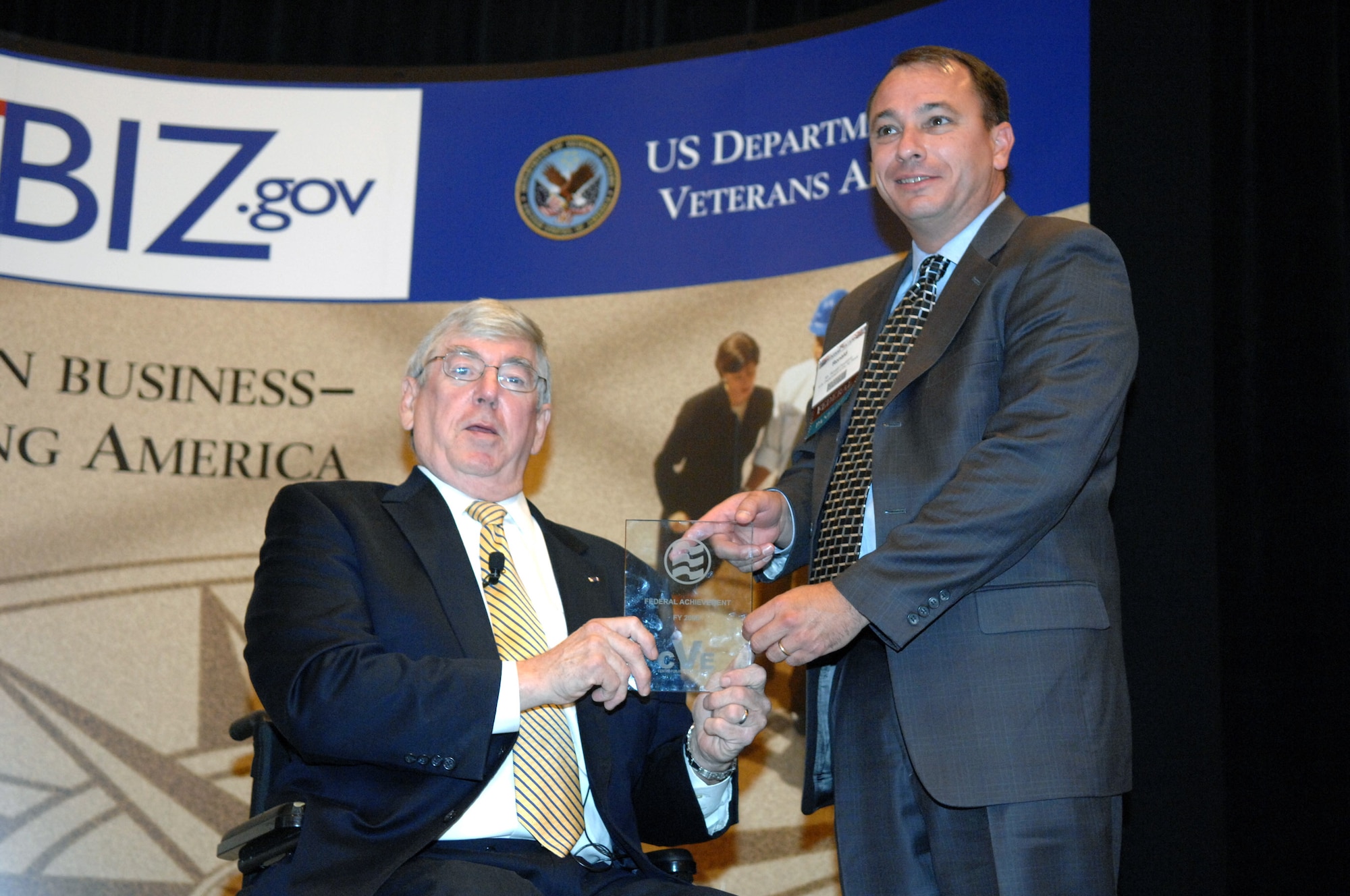 Deputy Secretary of Veterans Affairs Gordon H. Mansfield presents the Air Force Award to Ronald A. Poussard, director of Air Force Office of Small Business Programs during the 6th Annual Awards Program June 27 at Caesars Palace in Las Vegas. The Department of Veterans Affairs recognized 23 Air Force bases for achievement under the Champions of Veteran Enterprise program. (U.S Air Force photo/Senior Airman Larry E. Reid Jr.)