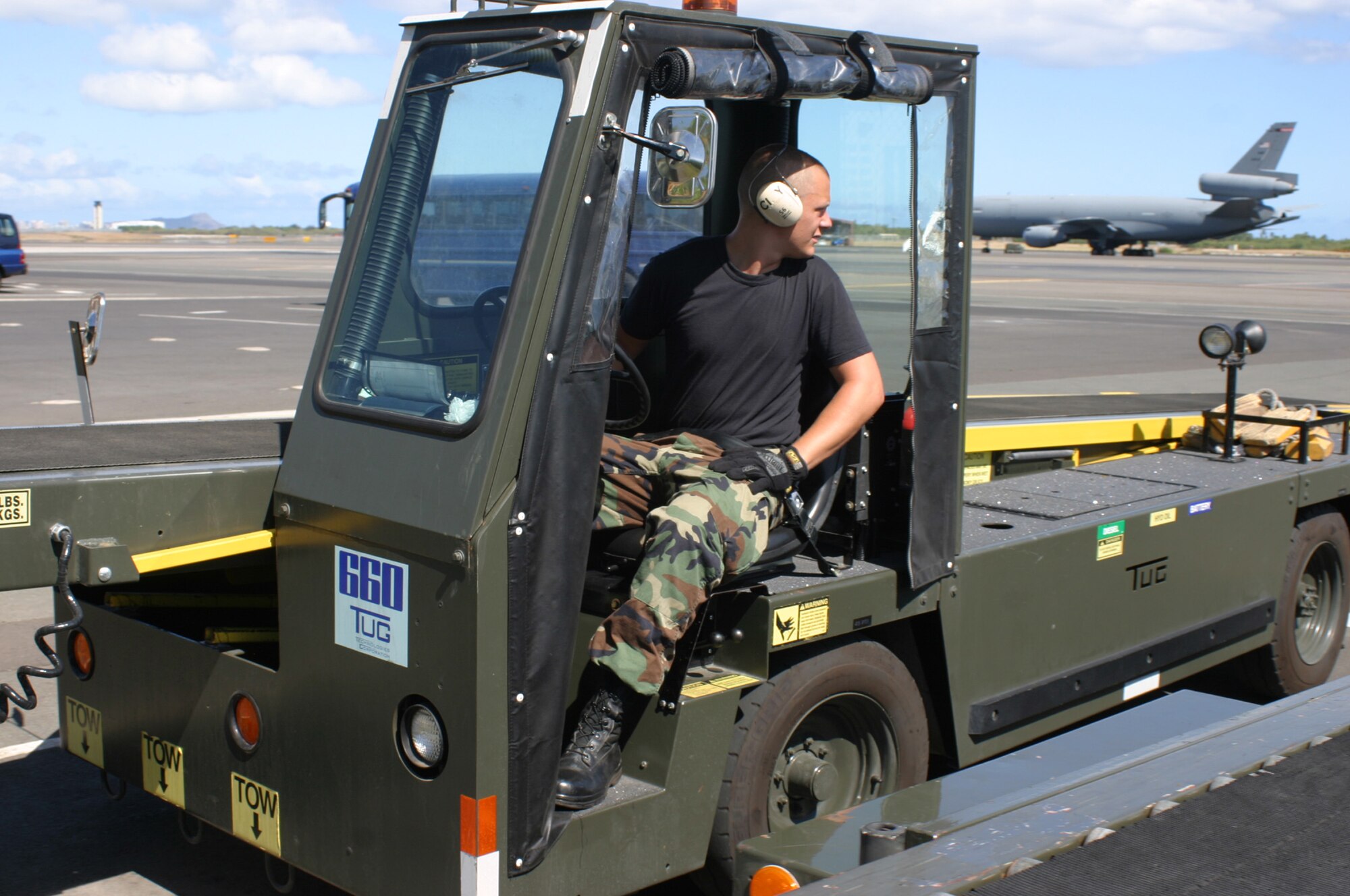 HICKAM AFB, Hawaii - Senior Airman Dustin Weidner, a passenger services specialist with the 87th Aerial Port Squadron deployed from Wright-Patterson AFB, Ohio, drives a baggage conveyor to load baggage on a KC-135. (U.S. Air Force photo/Master Sgt. Doug Moore)