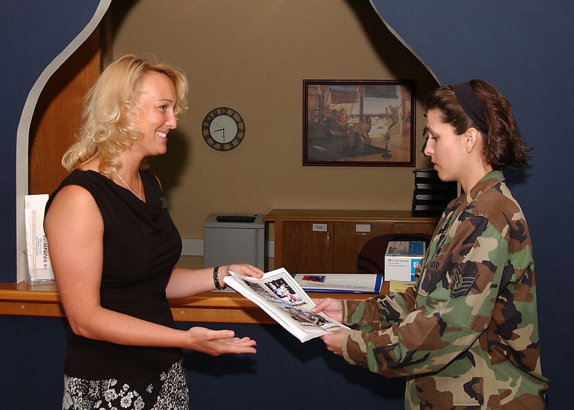 Jodie Parker, left, Mission Support Squadron community readiness consultant, hands out sponsorship information to Tech. Sgt. Jennifer Diaz, 39th Air Base Wing military equal opportunity non-commissioned officer in charge, at the Airman and Family Readiness Center, July 6.  Good sponsorship is paramount in transitioning Airmen to a new base.  (U. S. Air Force photo by Tech. Sgt. Patrick Hyde)   