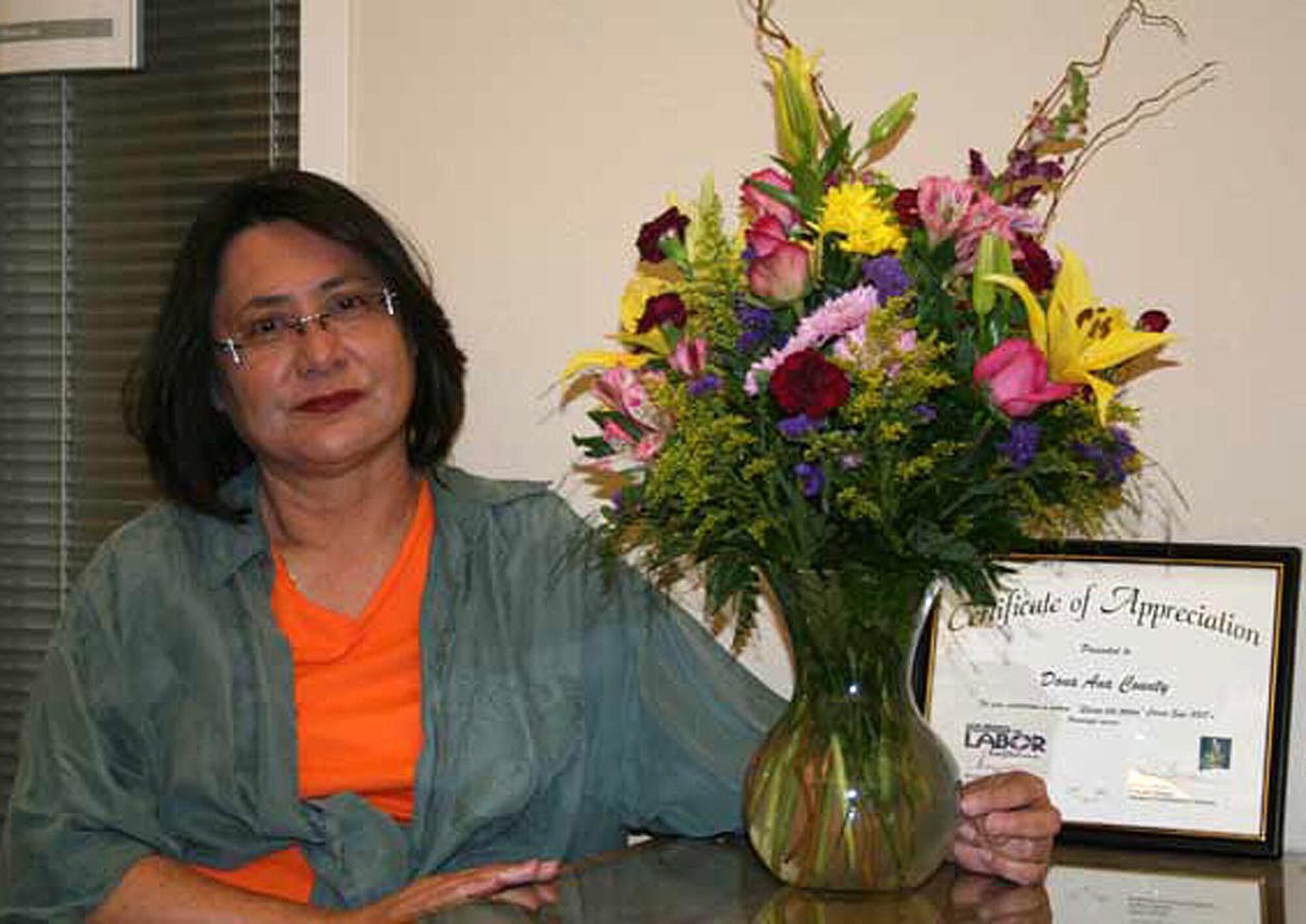 Mary Pierce, mother of Senior Airman Jennifer Cianfrocca, 354th Expeditionary Fighter Squadron intelligence, receives her flowers and certificate of appreciation on behalf of the Airmen of the 354th  Expeditionary Fighter Squadron and Expeditionary Aircraft Maintenance Unit. Mary Pierce was voted "Best Squadron Mom" by the Airmen for all of the care packages she has sent. (courtesy photo)