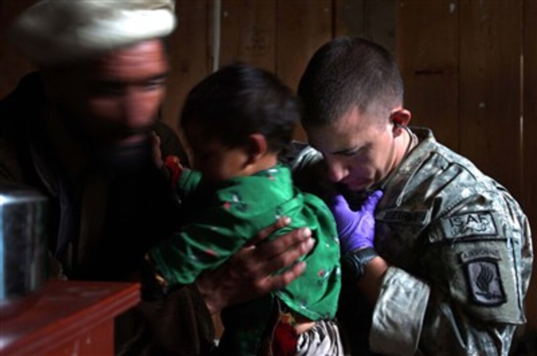 Staff. Sgt. Michael Ortiz, Headquarters and Headquarters Company, 2nd Battalion, 503rd Infantry Regiment (Airborne), listens to a local Afghan child’s heart during a medical civil action project in Parun, Afghanistan. Ortiz worked with another Coalition Forces medic to treat more than 60 patients.