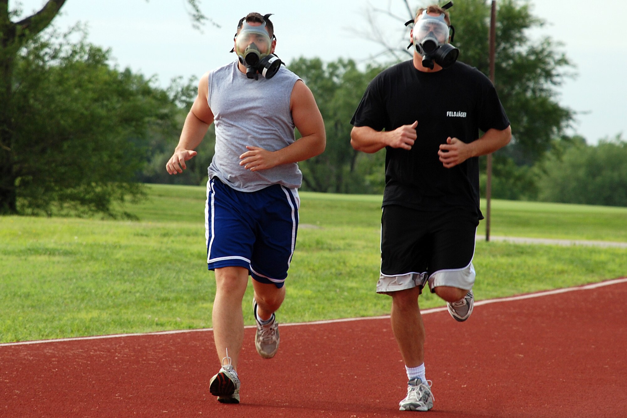 Rodeo team members Staff Sgt. Joseph Kitchen, 22nd Security Forces Squadron, and Staff Sgt. Gregory Podobensky, 22nd Security Forces Squadron, sprint down the base track with their gas masks on July 10. They train for this years Air Mobility Command’s Rodeo competition July 22-28, McCord Air Force Base, Wash. (Photo by Airman 1st Class Jessica Lockoski)