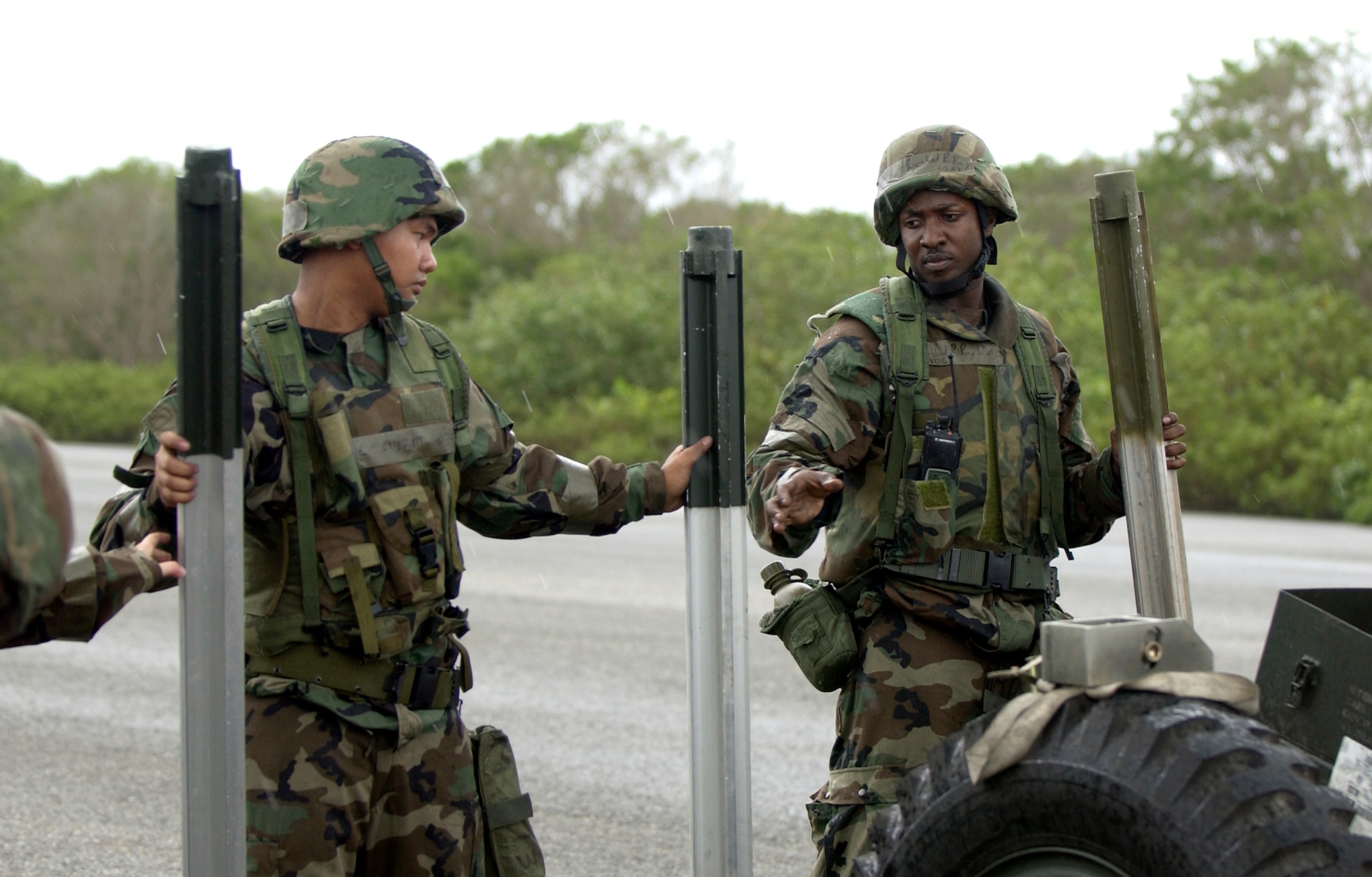 Airman 1st Class Vincent Manabatto passes equipment to Staff Sgt. Roeshod Ray, both from the 36th Civil Engineer Squadron, during an exercise, July 10 here. The 36 CES participated in a week-long exercise to test member's ability to deploy, as well as respond to real-world scenarios. (U.S. Air Force photo by Senior Airman Miranda Moorer)