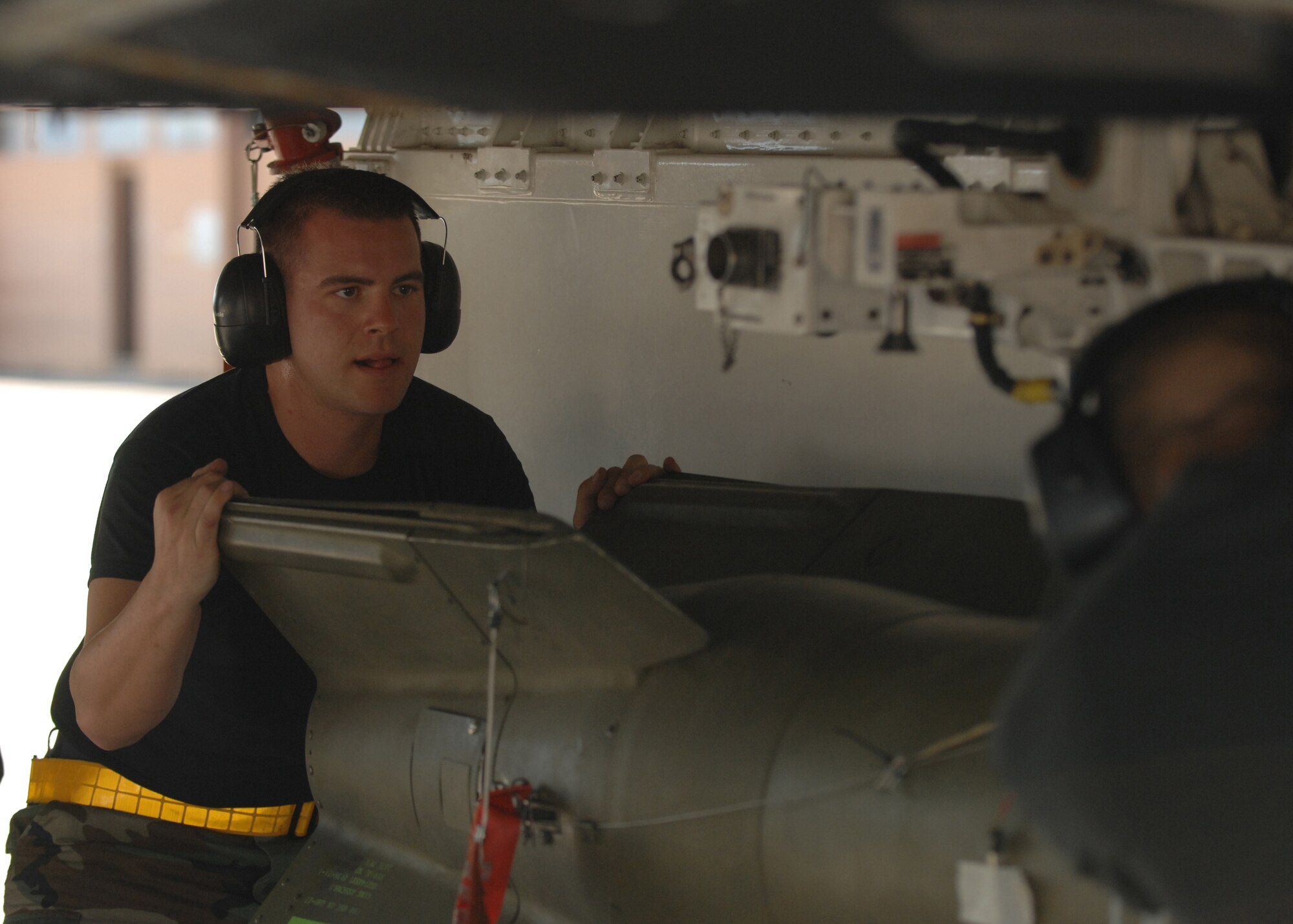 Airman 1st Class  Branden Sharp, 8th Aircraft Maintenance Unit, lines up the bomb suspension lugs to the MAU-12 bombrack as Senior Airman Joshua Reyes, also from the 8th Aircraft Maintenance Unit, prepares to lock the bomb to the MAU-12 during the Weapons Standardization Load Crew of the Quarter Competition July 9. (U.S. Air Force photo by Senior Airman Anthony Nelson Jr.)
