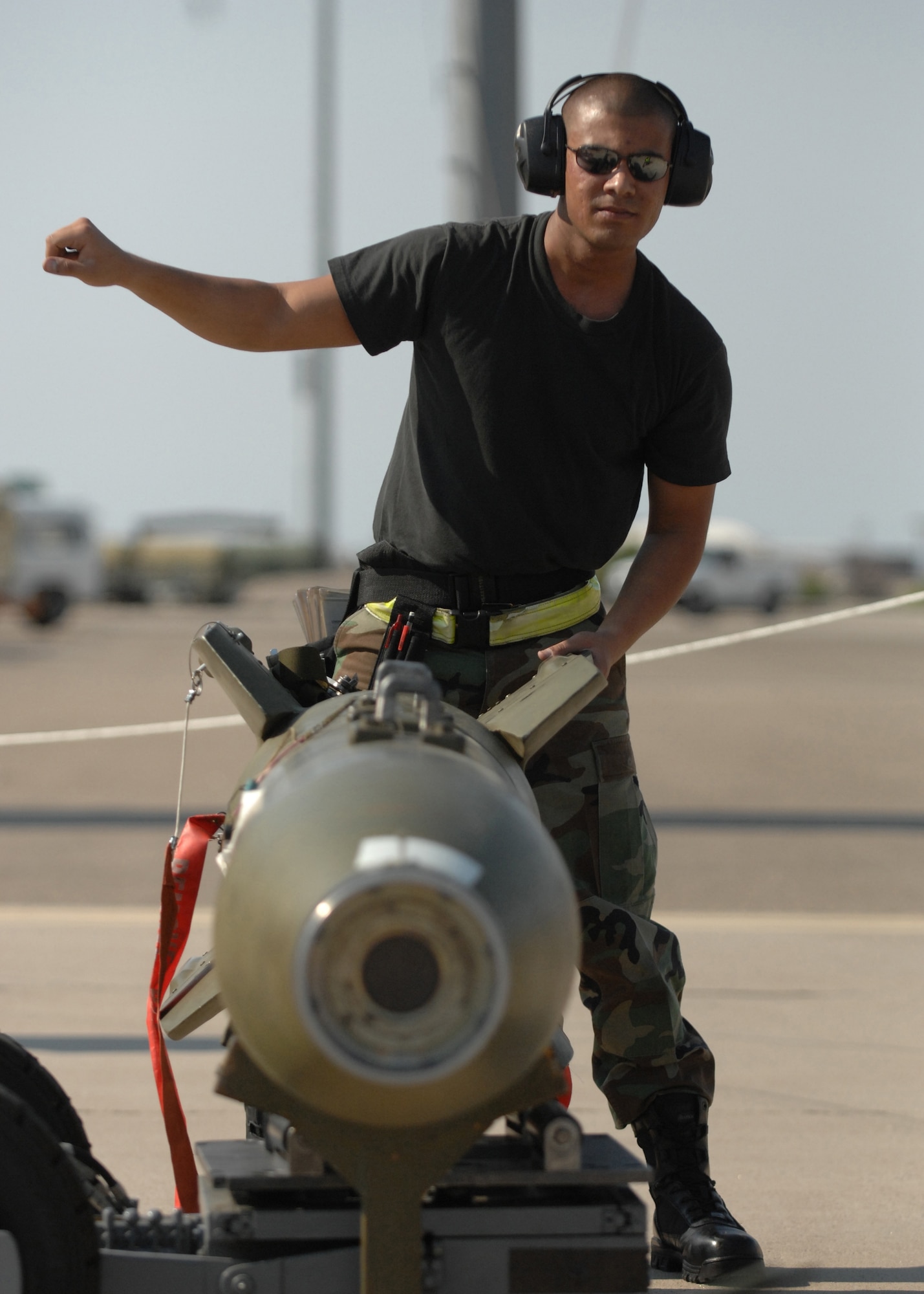Senior Airman Joshua Reyes, 8th Aircraft Maintenance Unit weapons load crew chief, aligns the bomb lift truck (MJ-1 "jammer") as A1C Johnson prepares to lift the bomb from the stand for loading onto the aircraft during the Weapons Standardization Load Crew of the Quarter Competition. (U.S. Air Force photo by Senior Airman Anthony Nelson Jr.)

