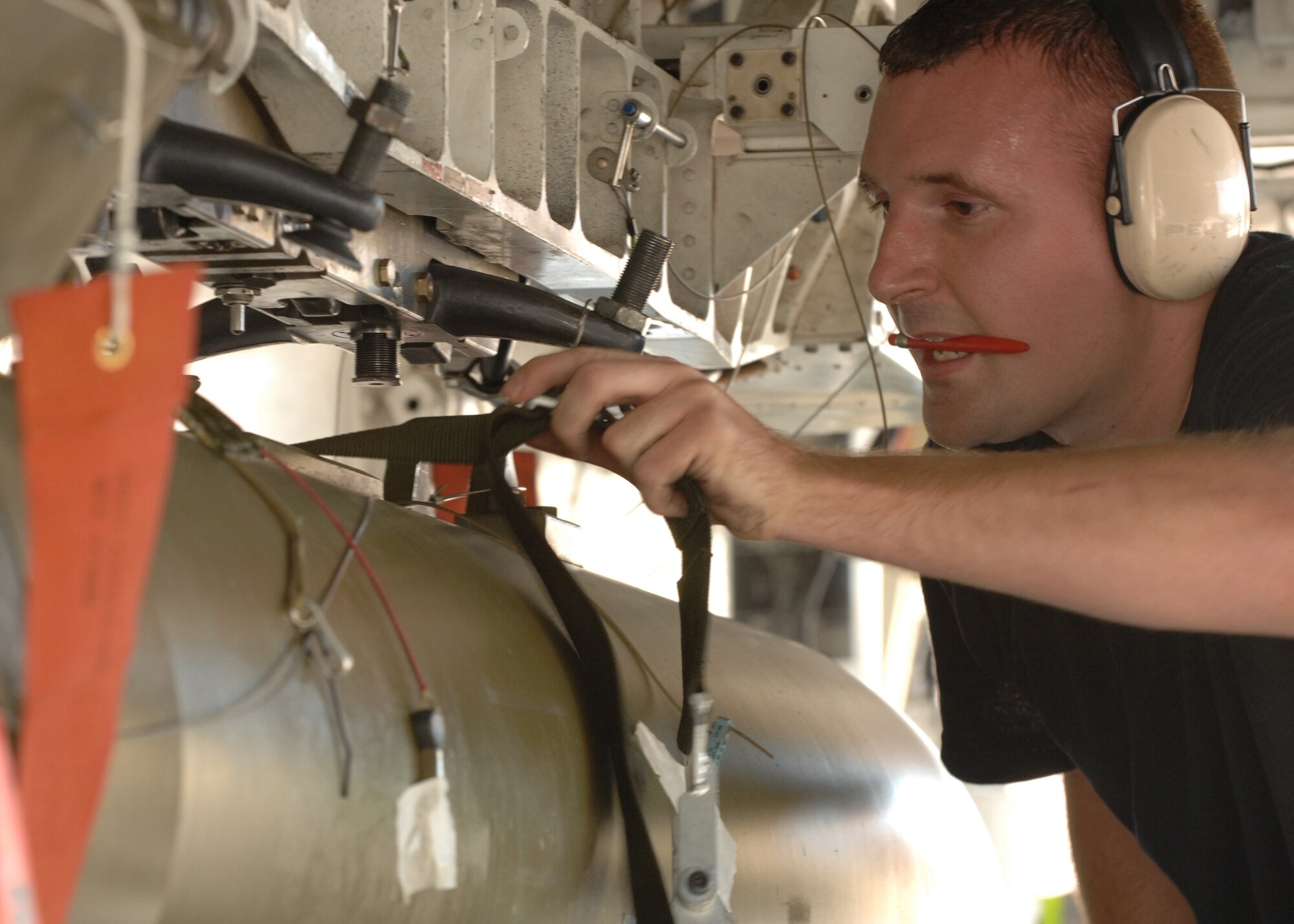 Staff Sgt. Christopher Osterholm, 9th Aircraft Maintenance Unit  weapons load crew member, unstraps the Guided Bomb Unit 27B (GBU) during the Weapons Standardization Load Crew of the Quarter Competition July 9.The Competition evaluates technical proficiency, safety procedures and overall time. (U.S. Air Force photo by Senior Airman Anthony Nelson Jr.)
