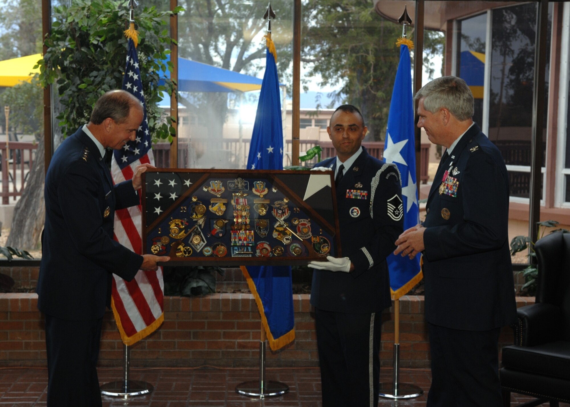 Gen. Kevin Chilton and Master Sgt. Paul Sanchez, Steel Talons NCOIC, present Colonel Moore his final retirement gift -- a shadow box.  (U.S. Air Force photo by Airman 1st Class Jamal Sutter)