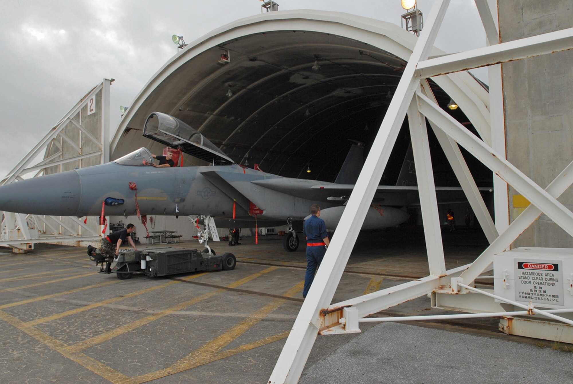 Airmen from the 18th Aircraft Maintenance Squadron tow an F-15 Eagle into a protective aircraft shelter in preparation for Typhoon Man-Yi July 12 at Kadena Air Base, Japan. Typhoon Man-Yi is expected to hit Okinawa July 13. It is the first typhoon of the year for the island. (U.S. Air Force/Airman 1st Class Kasey Zickmund)

