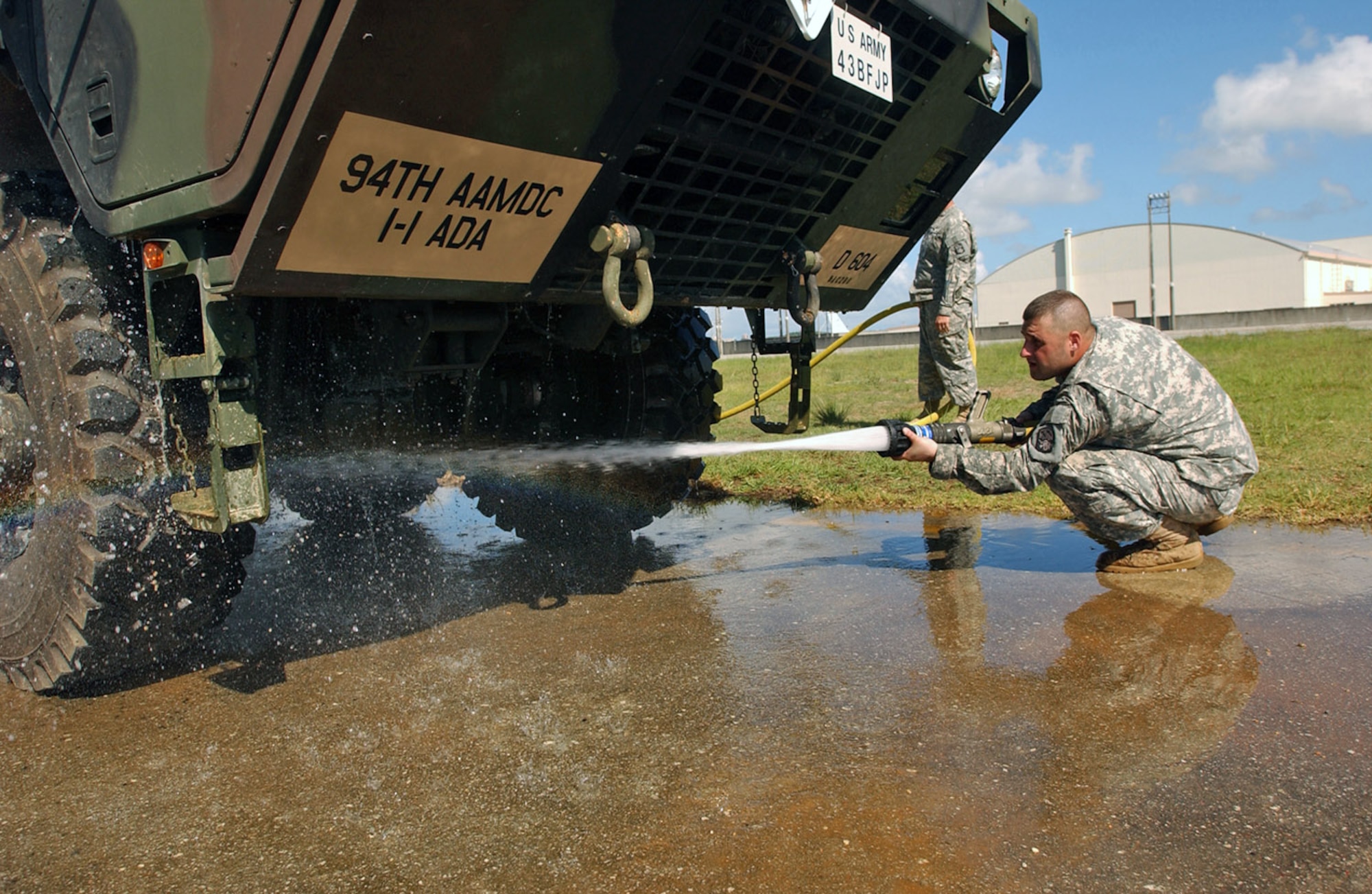 An Army Soldier from the 1-1 Air Defense Artillery Brigade washes a Hemmet along with the Patriot Advanced Capability missile equipment in preparation for Typhoon Man-Yi July 11 at Kadena Air Base, Japan. The 1-1 ADA stored their most valuable equipment in a hangar near the Kadena AB flightline in preparation for Typhoon Man-Yi, the first typhoon of the year for Okinawa. Before having them stored, both the equipment and vehicle are washed at Papa ramp to prevent foreign object damage. (U.S. Air Force photo/Staff Sgt. Reynaldo Ramon)
