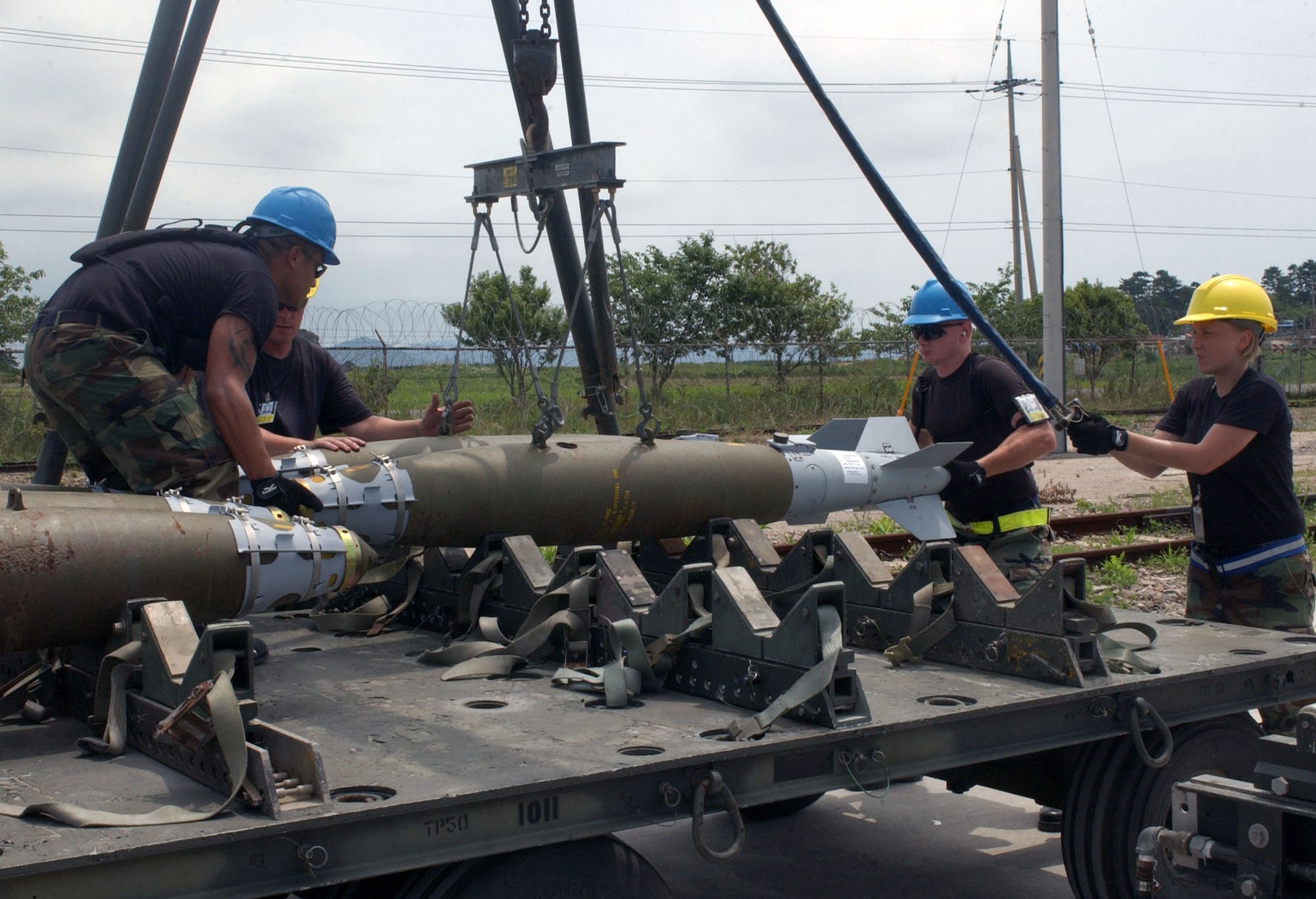 Airmen from the 51st Munitions Squadron at Osan Air Base, South Korea, remove bombs from a trailer July 11 during a combat ammunition production exercise being held at Kunsan AB, South Korea.  The three-day exercise provides Pacific Air Forces and Air Combat Command units with training in mass munitions assembly in support of aircraft sortie generation.  (U.S. Air Force photo/Senior Steven R. Doty)