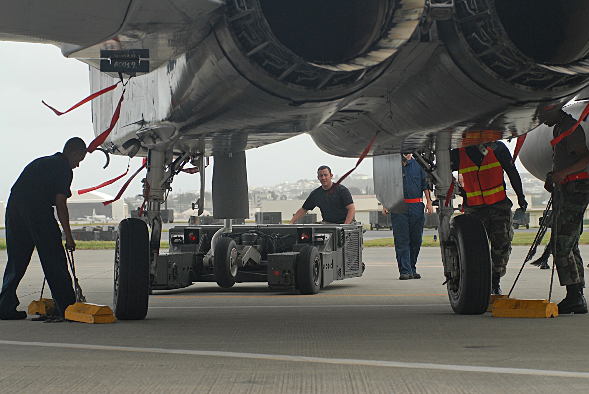 Staff Sgt. Justin Farr (center) drives an aircraft handler to place an F-15 Eagle in a protective aircraft shelter in preparation for Typhoon Man-Yi July 12 at Kadena Air Base, Japan. Typhoon Man-Yi is expected to hit Okinawa July 13. It is the first typhoon of the year for the island. Sergeant Farr is with the 18th Aircraft Maintenance Squadron. (U.S. Air Force photo/Airman 1st Class Kasey Zickmund)
