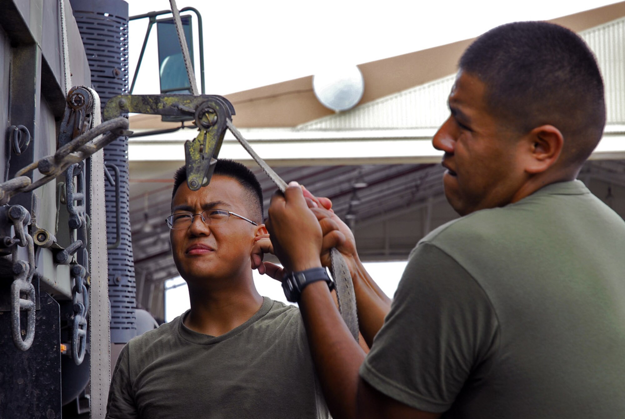 Marine Lance Cpl. Saysavanh Mainvong (left) watches as Marine Cpl. Samuel Kee secures containers onto a truck before relocating them to a secure building in preparation for Typhoon Man-Yi July 12 at Kadena Air Base, Japan. The typhoon is the first of the year for Okinawa and is expected to make landfall July 13. The corporals are assigned to Marine Wing Liaison Kadena. (U.S. Air Force photo/Airman 1st Class Sheila deVera) 
