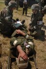 MINOT AIR FORCE BASE, N.D. – Airmen from the 5th medical Group here transport and treat an Airman for a simulated broken leg during a Phase II exercise. Phase II exercises evaluate Airmen's ability to operate and survive in deployed locations. (U.S. Air Force Photo by Senior Airman Stacy Moless)