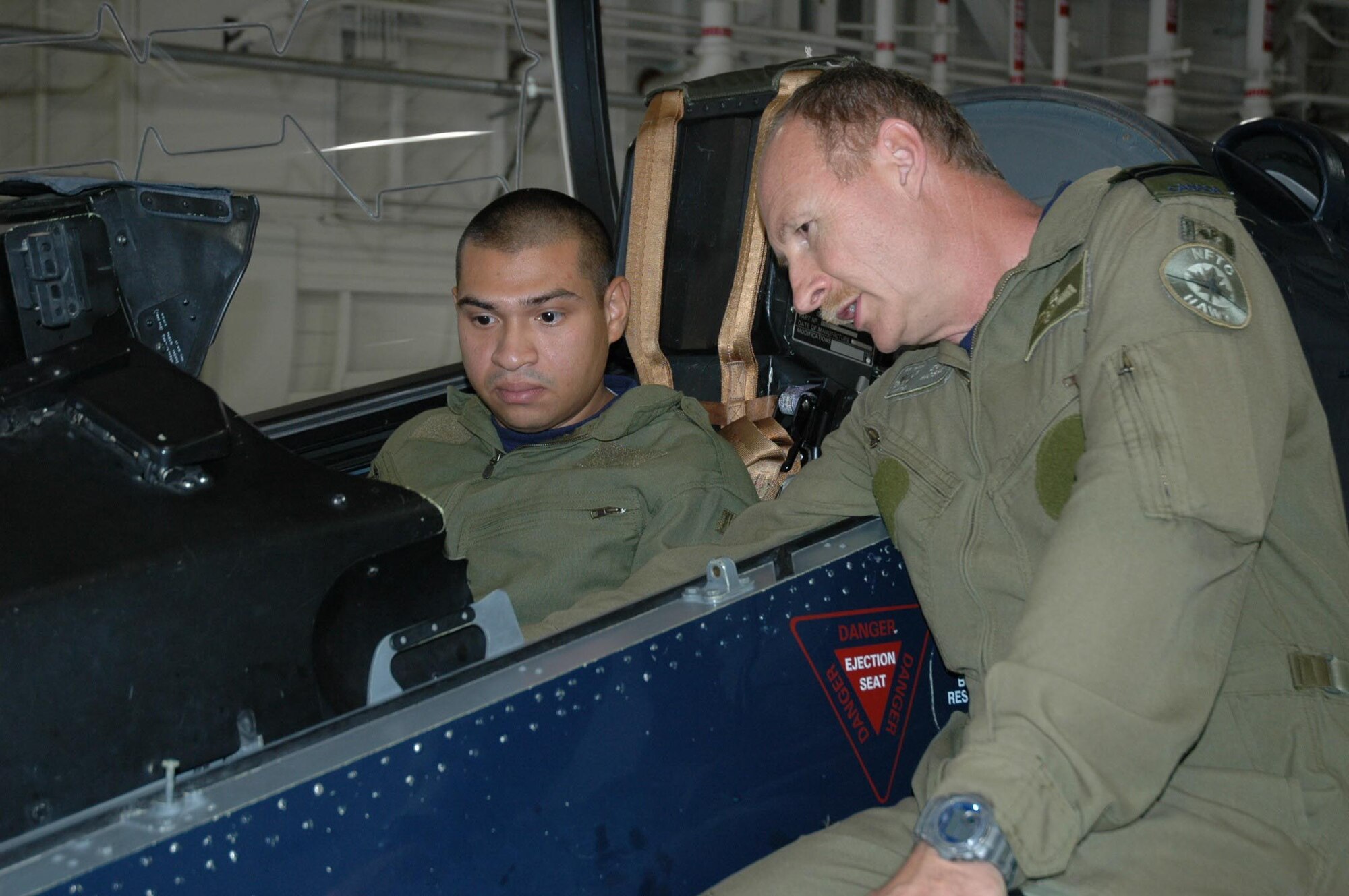 Captain Derek ?Duke? Mosher gives pre-flight instructions to Senior Airman Luna as he sits in the CT-155 Hawk.  (USAF photo/Senior Master Sgt. Marcus Falleaf)