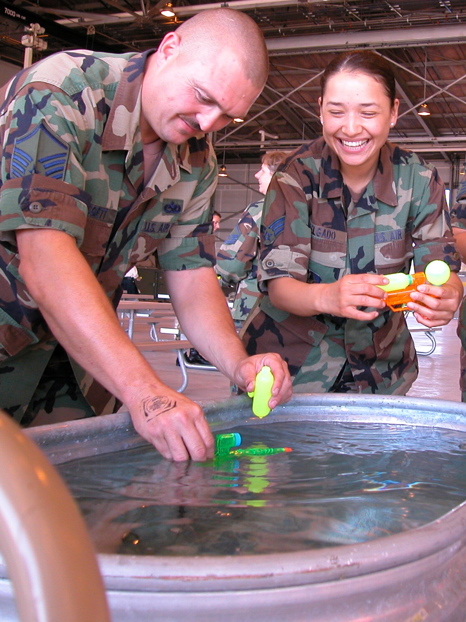 GRISSOM AIR RESERVE BASE, Ind., -- Master Sgt. Everett Liggett, left, 434th Maintenance Squadron, and Senior Airman Gisele Delgado, 434th Air Refueling Wing, fill their squirt guns at the watering trough at the start of the Combat Dining In. (U.S. Air Force photo/Senior Airman Chris Bolen)