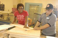 Staff Sgt. Petra Boerner gets some assistance on her woodworking project from Wood Shop Manager Julius Garcia at the Arts and Crafts Wood Shop at Lackland Air Force Base, Texas. (USAF photo by Lilly Flores-Janecek)                                 
