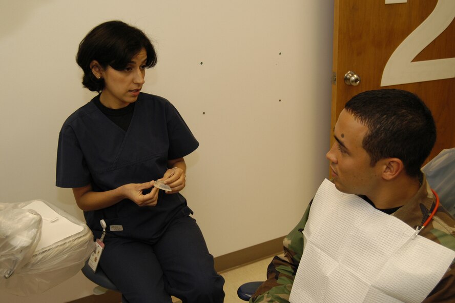 Maj. Elham Barani, 436th Aeromedical Dental Operations Squadron dentist, speaks with Airman James Perry, 436th Medical Operations Squadron, about his oral health July 11. Major Barani recently applied for a two-year Endodontic Residency. (U.S. Air Force photo/Senior Airman James Bolinger) 