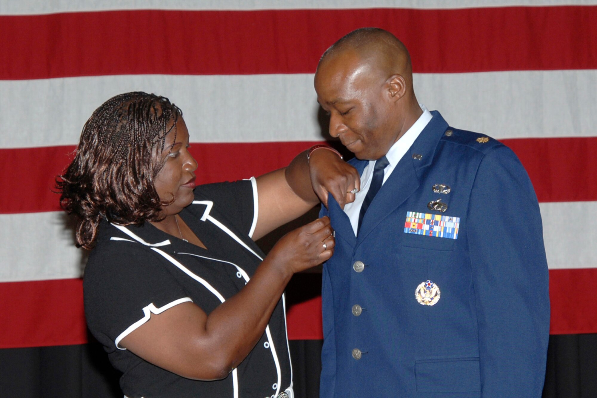 MCCONNELL AIR FORCE BASE, Kan. -- Sheryl Davis places a commander’s pin on her husband, Maj. James Davis, July 5, during a change-of-command ceremony in the Robert J. Dole Community Center ballroom, during which Major Davis took command of the 22nd Contracting Squadron from Lt. Col. Marvin Baugh. (Photo by Airman 1st Class Roy Lynch)

