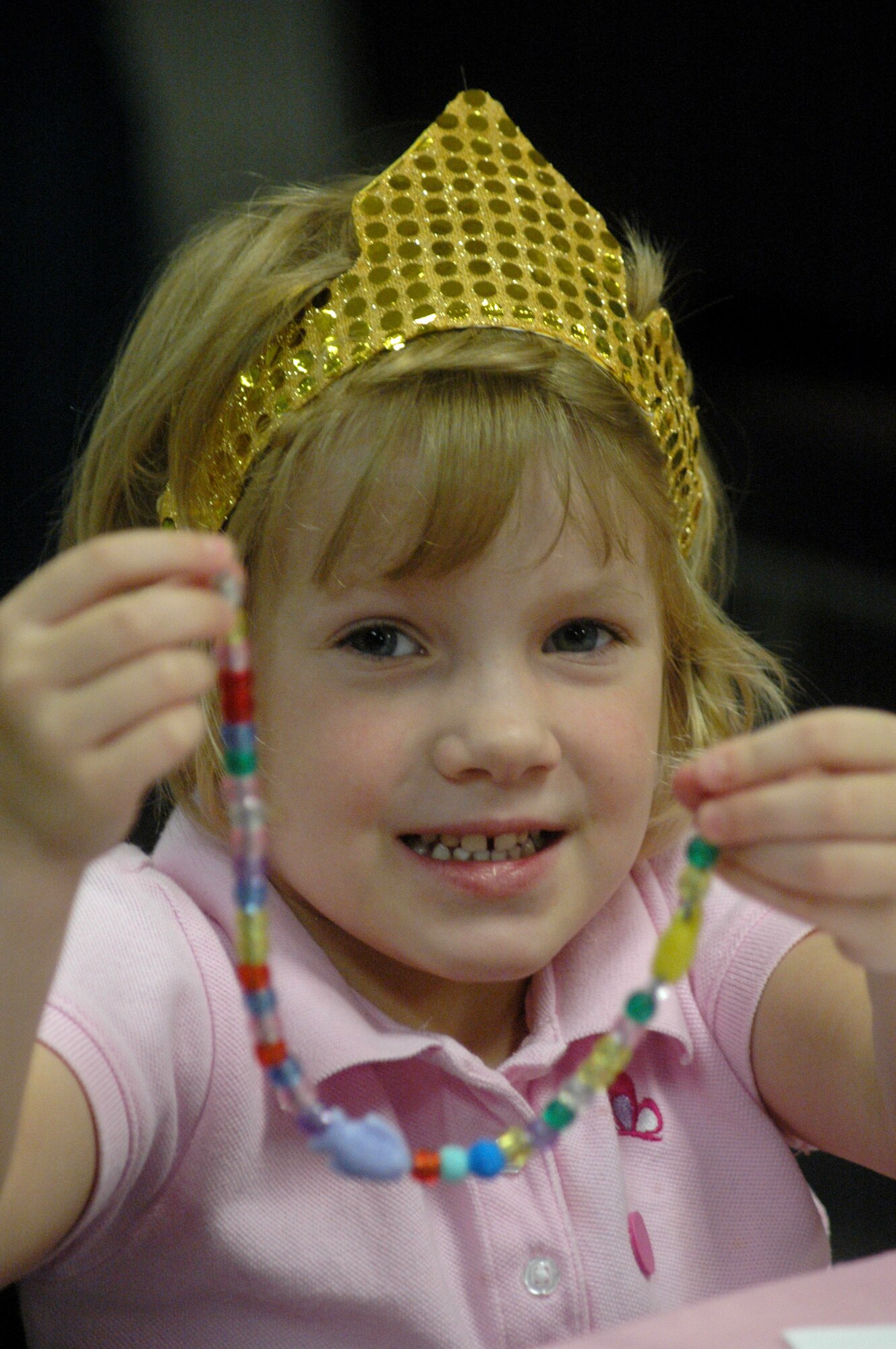 Cameron Owens, 4,shows off the  jewelry she created with beads at Princess Camp.  U. S. Air Force photo by Sue Sapp 