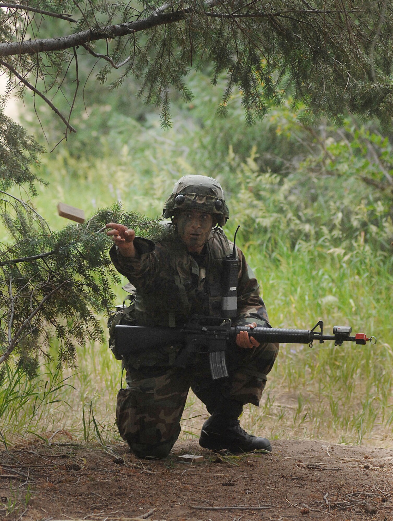Cadet 3rd Class Farino Salvatore throws ammunition to a fellow cadet while being attacked by opposition forces during the Global Engagement course July 10 at the U.S. Air Force Academy in Colorado. The purpose of Global Engagement is to lay the foundation for Air Force Academy Cadets of attitudes, knowledge and skills necessary to lead, fight, and win in a dynamic and diverse global environment. (U.S. Air Force photo/Tech. Sgt. Larry A. Simmons)