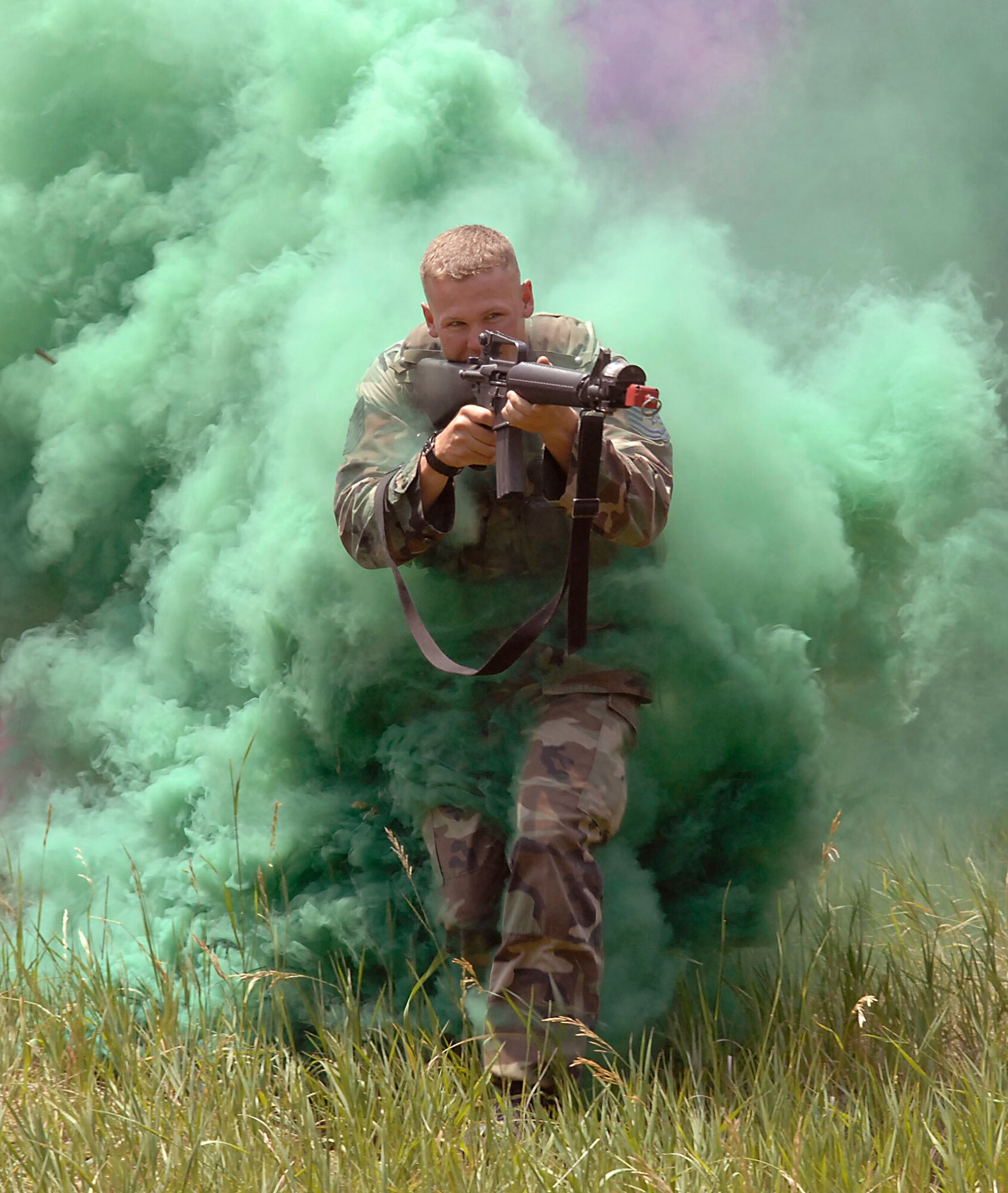 Tech. Sgt. Kevin Akers runs through cover smoke while attacking defensive firing positions manned by U.S. Air Force Academy cadets during the Global Engagement course July 11 at the Academy in Colorado. The purpose of Global Engagement is to lay the foundation of attitudes, knowledge and skills necessary to lead, fight, and win in a dynamic and diverse global environment. Sergeant Akers is a security forces instructor from Moody Air Force Base, Ga. (U.S. Air Force photo/Tech. Sgt. Larry A. Simmons)

