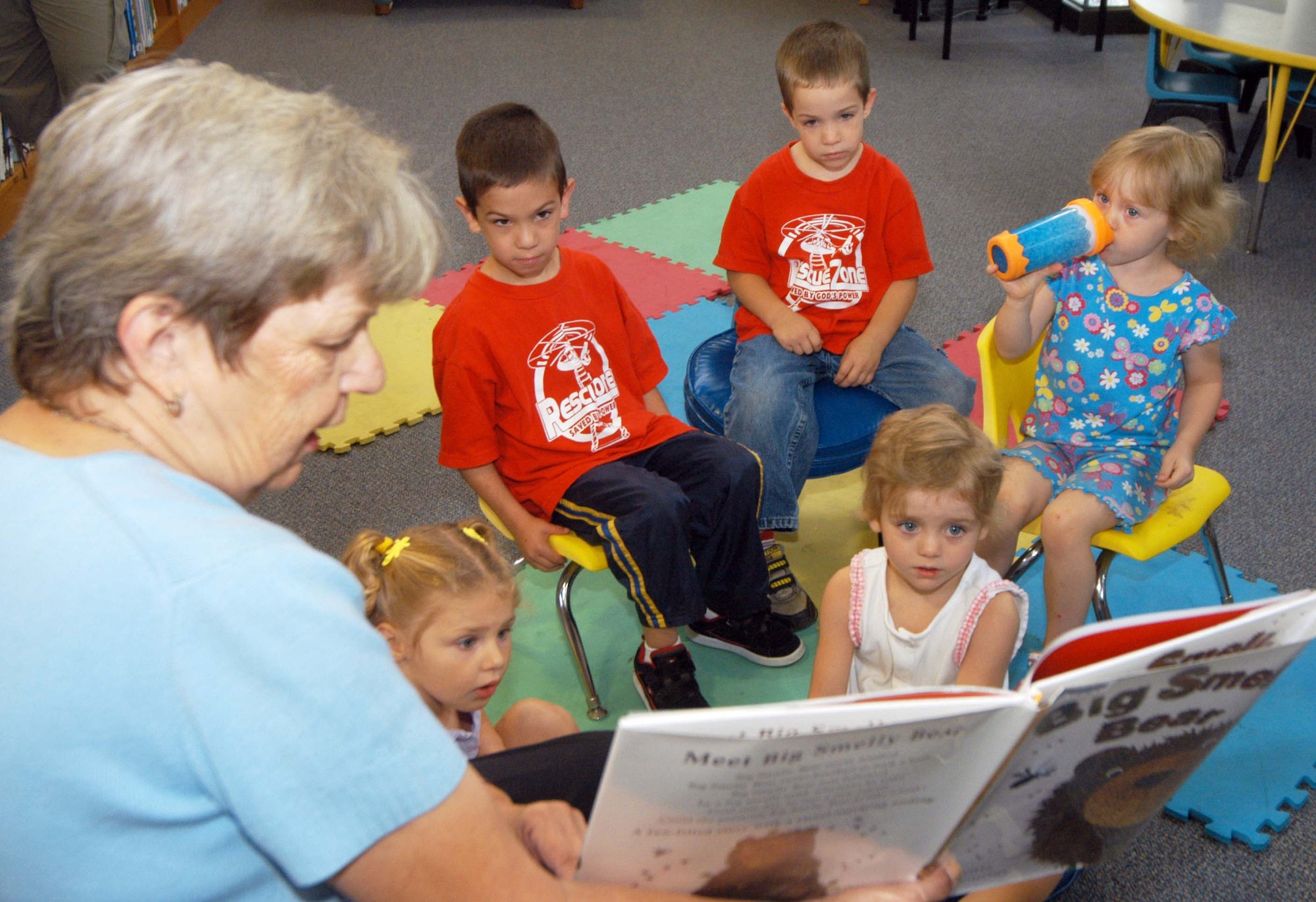Blanchella Casey, supervisory librarian, reads the book, "Big Smelly Bear" to preschool children at the library July 2. U. S. Air Force photo by Sue Sapp  