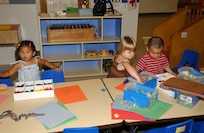 Neila Rae Mangiliman, left, prepares to color while Frankie Calnicean and A.J. Wong, all 2-year-olds, choose their favorite blocks to build with at Children's Playgroup on Lackland Air Force Base, Texas. Playgroup is held in Bldg. 8205. Neila is the daughter of Norilyn and Staff Sgt. Restie Mangiliman of the 59th Medical Operations Squadron. Frankie is the daughter of Karen and Capt. Michael Calnicean of the 59th Aerospace Medicine Squadron. A.J. is the son of Nancy and Capt. Aaron Wong of the 33rd Information Operations Squadron. (USAF photo by Mondo Flores)                               