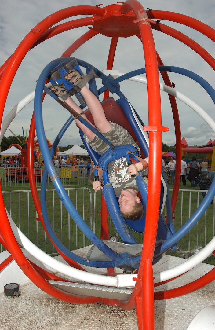 Strapped in and secure, 8-year-old Riley Naylor, son of Suzanne and Col. Richard Naylor, 37th Training Group commander, takes a spin in the patriotic-colored Space Ball during the 2007 Star Spangled Festival at Lackland Air Force Base, Texas, on Independence Day. (USAF photo by Alan Boedeker)                               