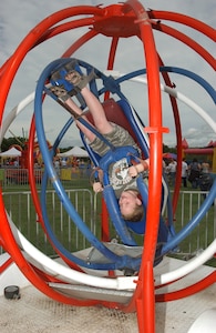 Strapped in and secure, 8-year-old Riley Naylor, son of Suzanne and Col. Richard Naylor, 37th Training Group commander, takes a spin in the patriotic-colored Space Ball during the 2007 Star Spangled Festival at Lackland Air Force Base, Texas, on Independence Day. (USAF photo by Alan Boedeker)                               