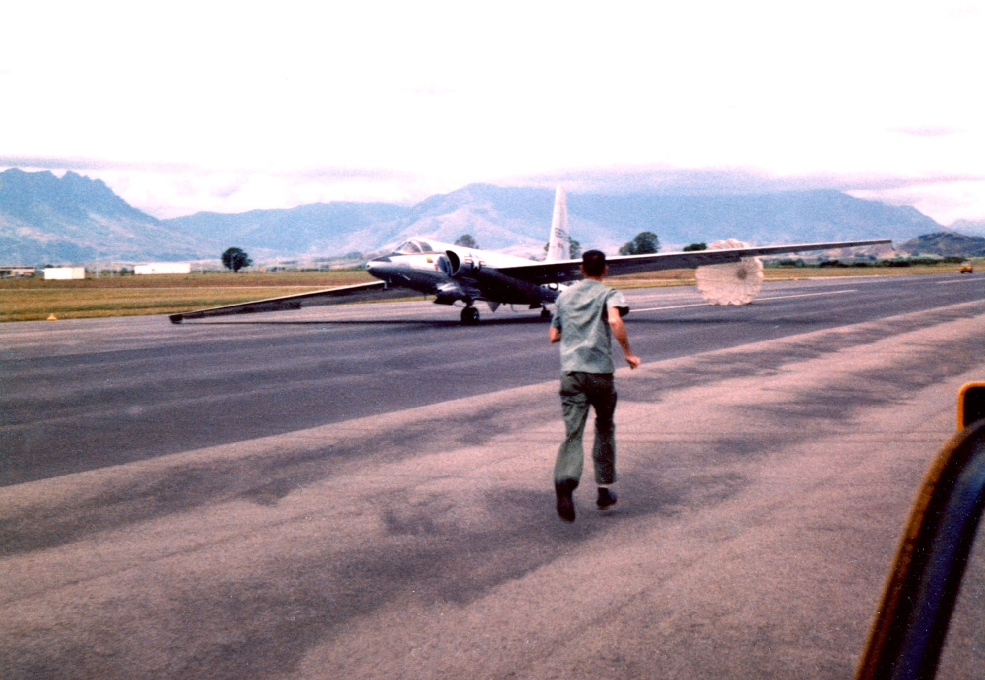 A USAF U-2 equipped for High Altitude Sampling Program (HASP) missions. The aircraft lands and characteristically falls to one side on its wing skids as it slows. A ground crewman runs to collect the braking parachute. Others inserted “pogo” wheels in the wings to right the aircraft and allow it to maneuver on the ground. The U-2 in this picture is on Fiji Island en route to Australia in 1961. (U.S. Air Force photo)