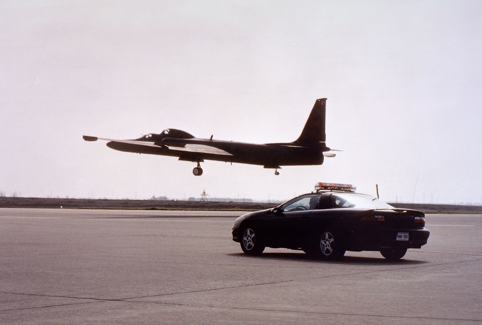 Dual cockpit TU-2S, the training version of the U-2 in which the instructor sits behind the student, being followed down the runway during landing by a chase car. (U.S. Air Force photo)