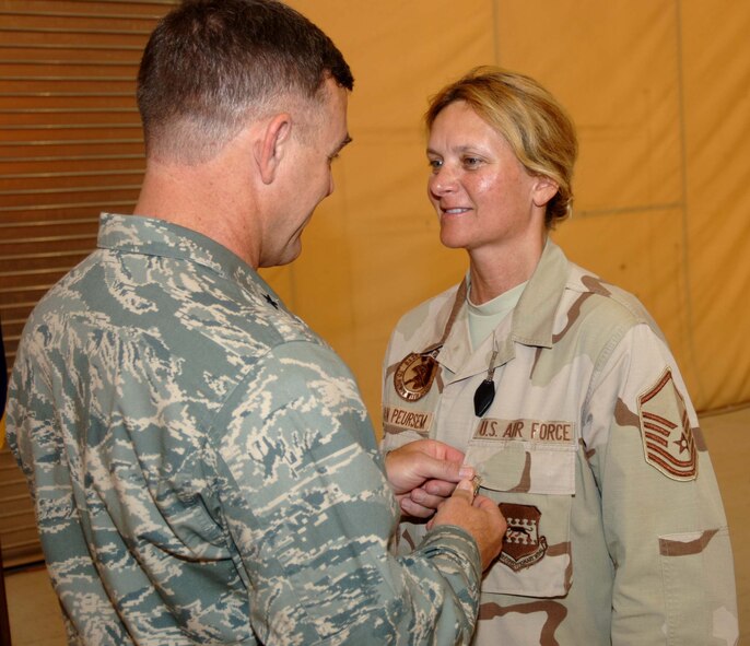 Sather Air Base, Iraq - Reserve Master Sgt Luann Van Peursem, 914th Logistic Readiness Squadron, receives the Air Force Commendation Medal with Valor from Brig Gen Burton Field, 332nd Air Expeditionary Wing on July 12. MSgt Van Peursem rendered first aid and initial medical care for two 914th  LRS members, TSgts Steve Paddison and Tim Juliano who were critically injured by shrapnel when a rocket exploded outside their building in Baghdad recently. TSgt Paddison is recovering at Walter Reed and TSgt Juliano is at McGuire Veterans Hospital in Richmond, Virginia and is expected to return to home soon. (Photo by: TSgt Russell Wicke)