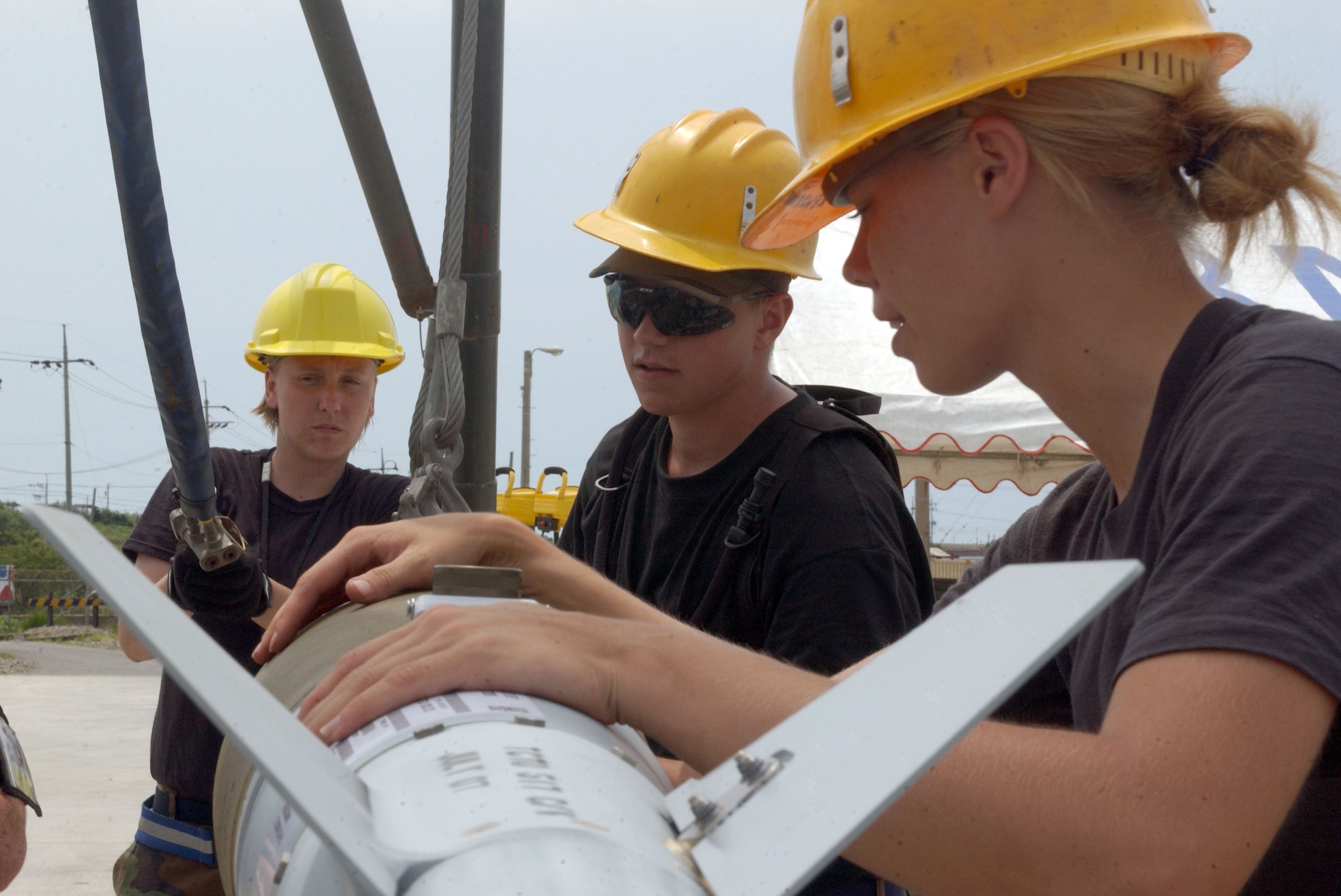 KUNSAN AIR BASE, Republic of Korea -- (From L to R) Senior Airman Natalie Huntington and Senior Airman Thomas Newell from Osan Air Base, along with Airman 1st Class Stephanie Nelson, Aviano Air Base Italy, team together to unload munitions in order to disassemble and pack it for "shipment" during the CAPEX here  July 11. (U.S. Air Force photo/Senior Airman Steven R. Doty)                                