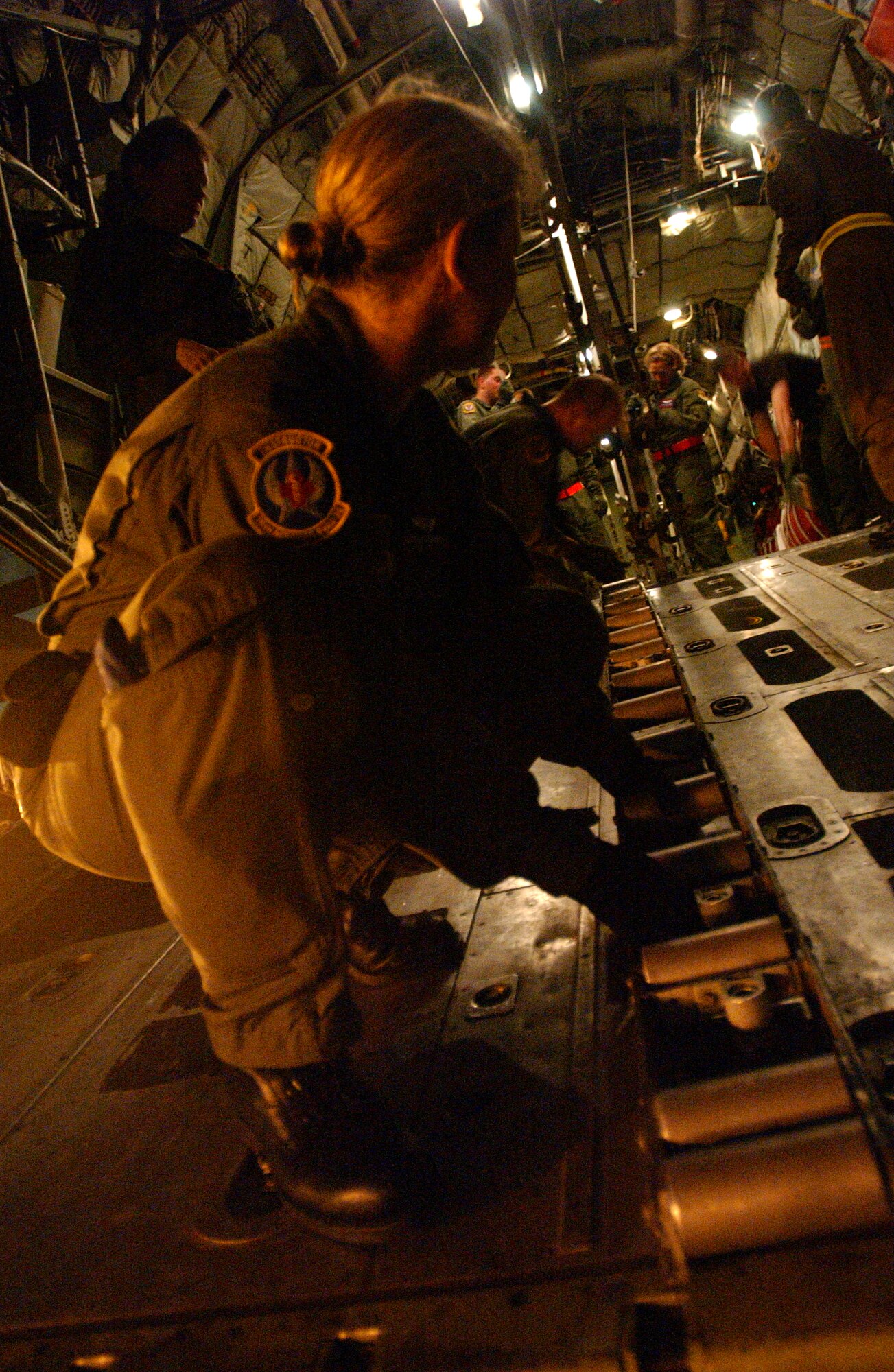 Personnel from the 18th Aeromedical Evacuation Squadron, Kadena Air Base, Japan, train on a C-130 Hercules at Marine Corps Air Station Futenma, Japan, in preparation for Air Mobility Rodeo 2007. Before practicing, the aircraft must be configured by removing rails on the floor and connecting all extension poles to make it aerial evacuation capable. U.S. Air Force photo/Staff Sgt. Reynaldo Ramon


