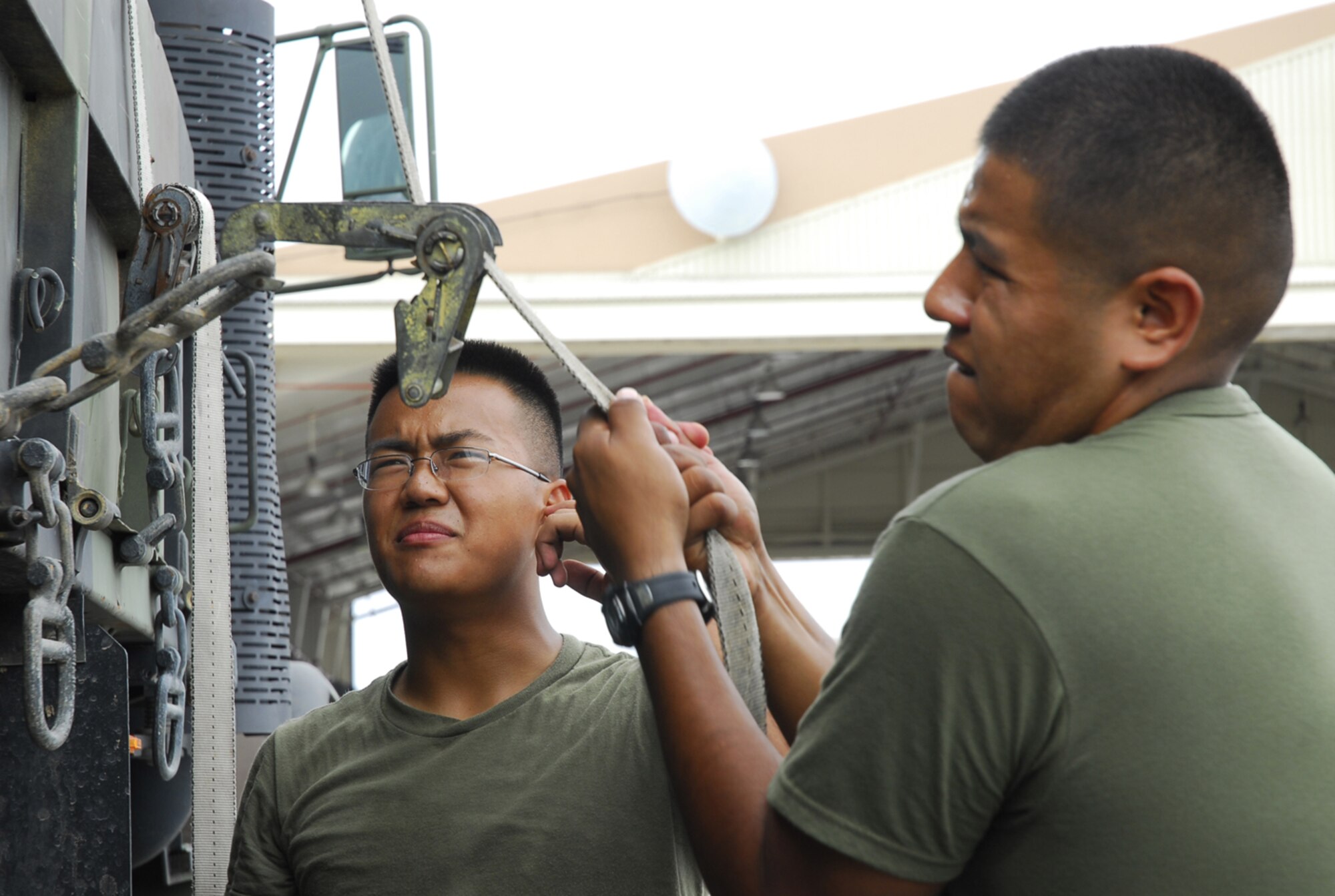 Lance Cpl. Saysavanh Mainvong watches as Cpl. Samuel Kee secures containers onto a truck before relocating them to a secure building at Kadena Air Base, Japan, July 12, 2007 in preparation for Typhoon Man-Yi. The typhoon is the first of the year for Okinawa, is expected to make landfall Friday. The corporals are assigned to Marine Wing Liasion Kadena.  U.S. Air Force photo/Airman 1st Class Sheila deVera