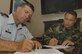 Col. Mark Barrett, 1st Fighter Wing commander and Chief Master Sgt. James MacKinley, 1st FW command chief, sign the first privatized housing leases July 9. Langley privatization community information meetings are scheduled for July 12 at the base theater from 9 to 10:30 a.m., 1 to 2:30 p.m. and 3 to 4:30 p.m. (U.S. Air Force Photo/Senior Airman Tabitha Kuykendall)