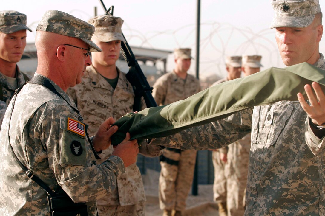 AL TAQADDUM, Iraq (July 13, 2007) ? Sgt. Maj. Terry S. Koenig and Lt. Col. Gregg L. Parks case their battalion?s organizational colors in a transfer of authority ceremony here July 13.  The 2nd Combined Arms Battalion, 136th Infantry Regiment handed the reins of his unit?s area of operations over to 1st Battalion, 11th Marine Regiment after 16 months of continuous combat operations.  Koenig is the sergeant major of 2-136 and Parks is the battalion commander.  The 2-136 is a Twin Lakes, Minn., based unit.
