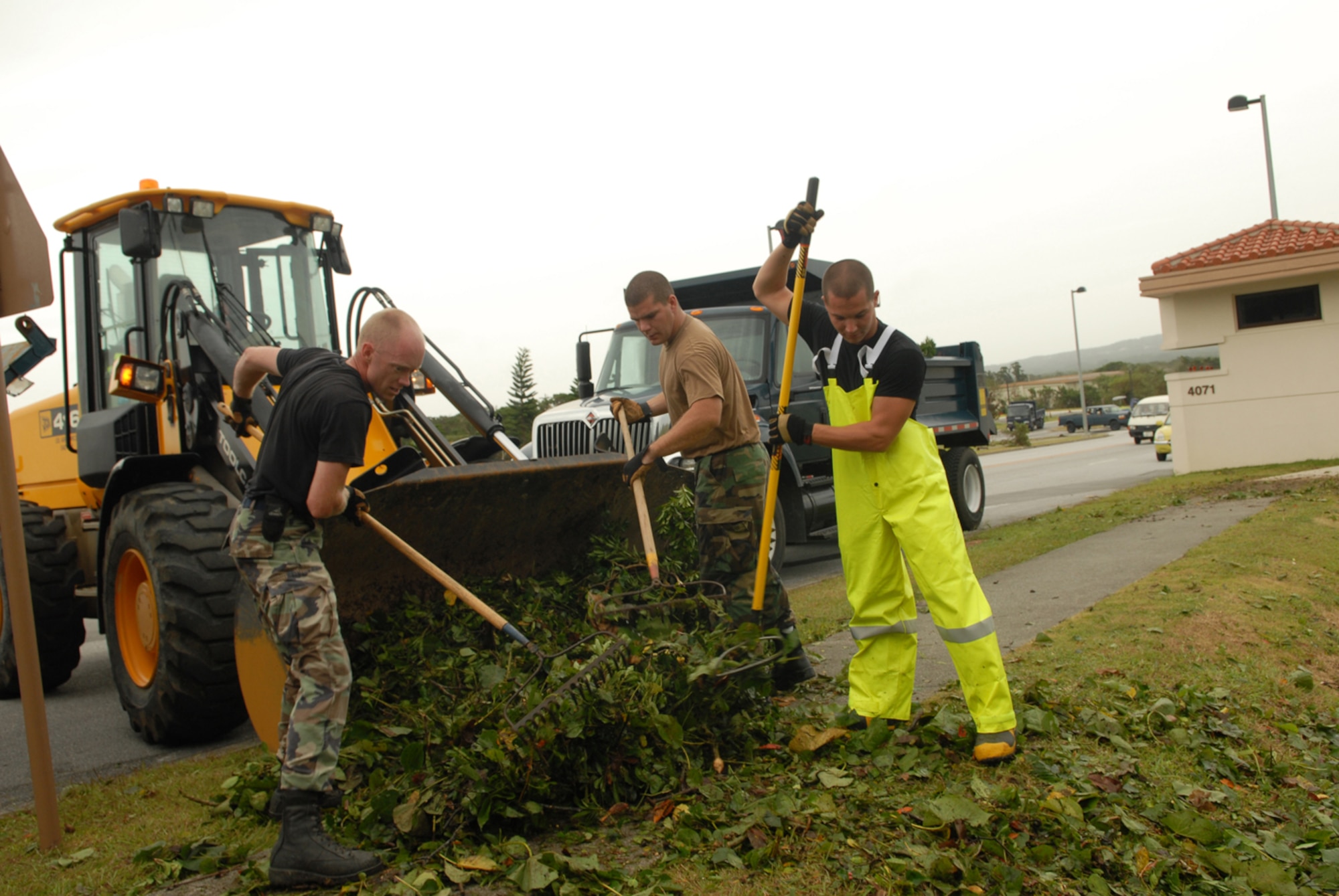 From left:  Staff Sgt. David Sanders and Airmen 1st Class Charles Grandy and  Thomas Fern remove debris from a drain onto a bulldozer at Kadena Air Base, Japan, July 14, 2007. The debris was a result of Typhoon Man-Yi which brought the base 77 mph winds gusting to 105 mph.  There were no injuries or significant damages to base structures.  The typhoon was the strongest to hit the base since 2003.  All are assigned to the 18th Civil Engineer Squadron.  (U.S. Air Force Photo by Staff Sgt. Chrissy FitzGerald