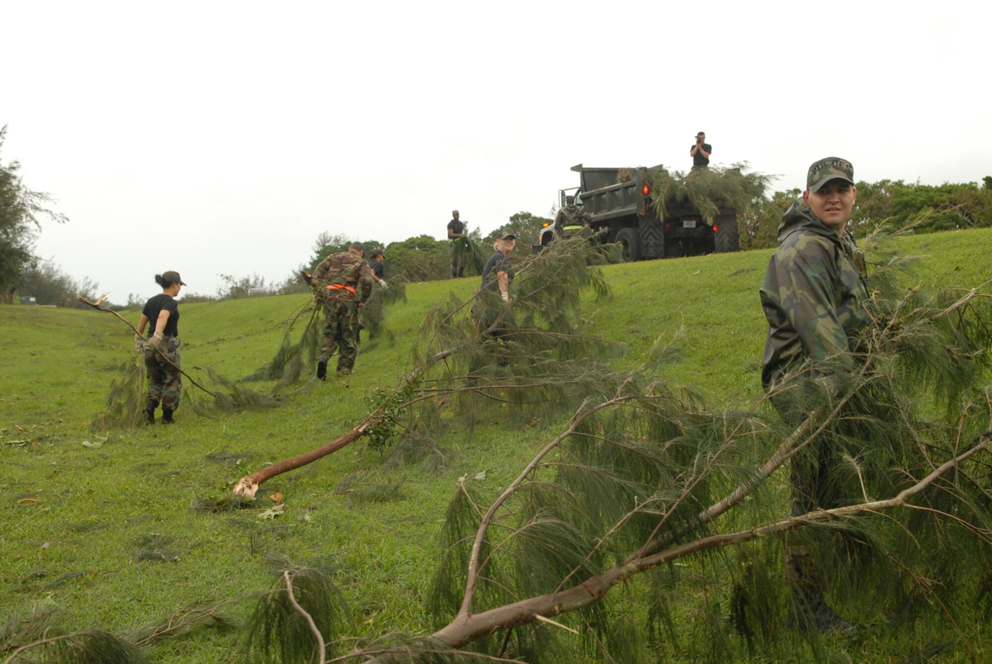 Airmen from the 18th Civil Engineer Group gather tree branches into a pile at Kadena Air Base, Japan, July 14, 2007. The branches were knocked down by Typhoon Man-Yi which brought the base 77 mph winds gusting to 105 mph.  There were no injuries or significant damages to base structures.  The typhoon was the strongest to hit the base since 2003.  Both Airmen are assigned to the 18th Civil Engineer Squadron.  U.S. Air Force Photo/Staff Sgt. Chrissy FitzGerald