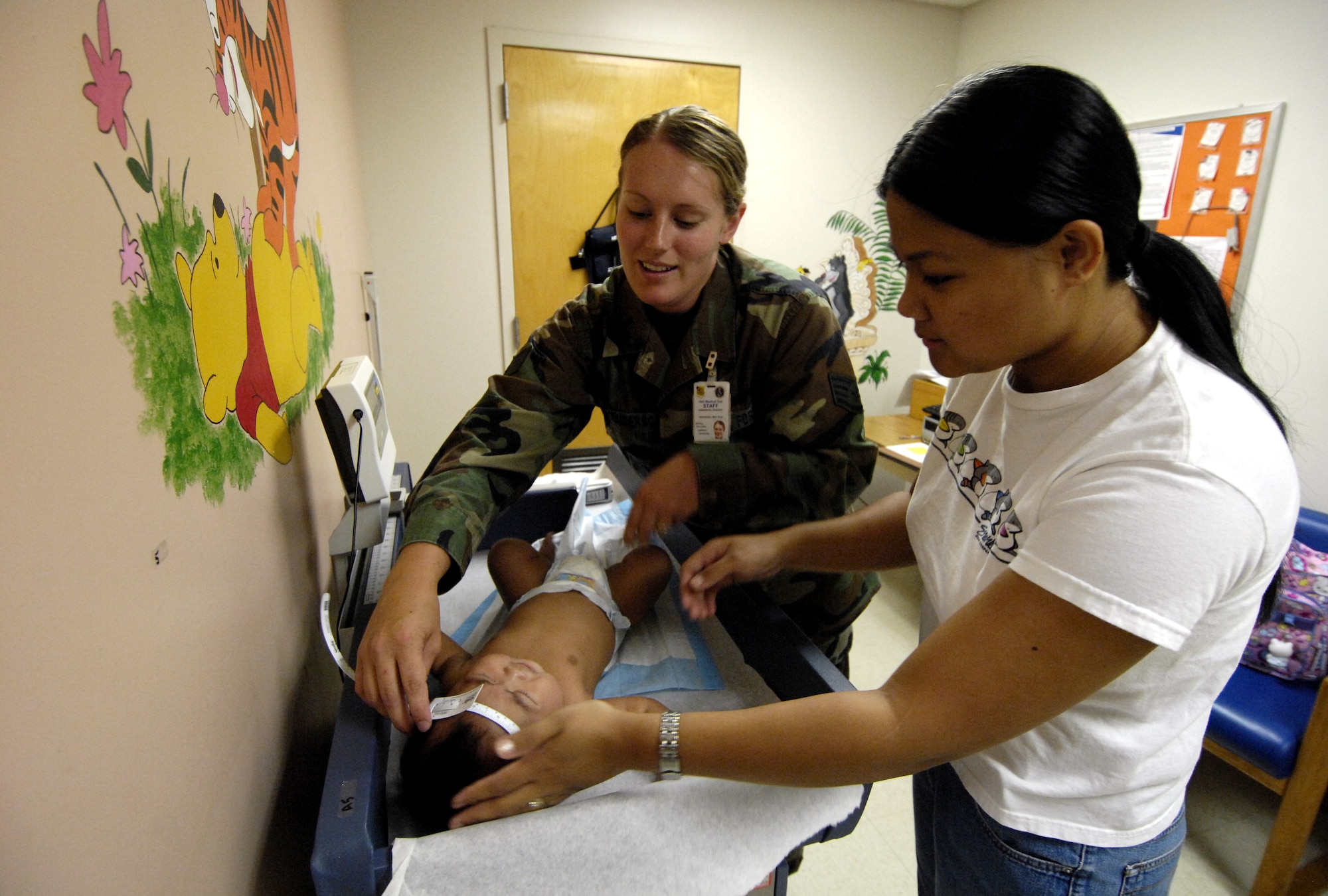 HICKAM AIR FORCE BASE, Hawaii -- Staff Sgt. Jennifer Henderson measures the head circumference of her patient July 11 at the clinic here. Sergeant Henderson is an aerospace medical technician with the 15th Medical Group. (U.S. Air Force photo/Tech. Sgt. Shane A. Cuomo)