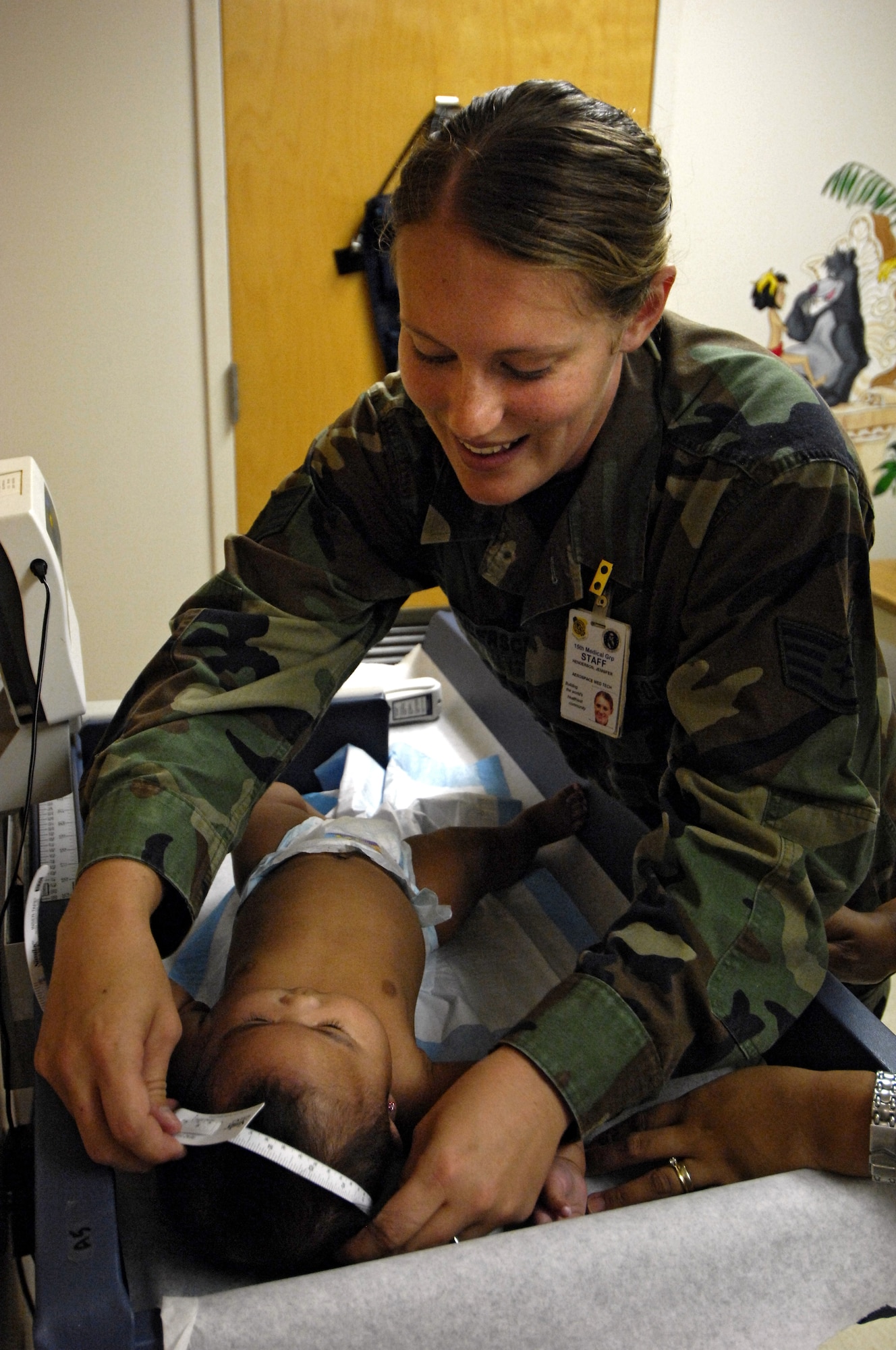 HICKAM AIR FORCE BASE, Hawaii -- Staff Sgt. Jennifer Henderson measures the head circumference of her patient July 11 at the clinic here. Sergeant Henderson is an aerospace medical technician with the 15th Medical Group. (U.S. Air Force photo/Tech. Sgt. Shane A. Cuomo)
