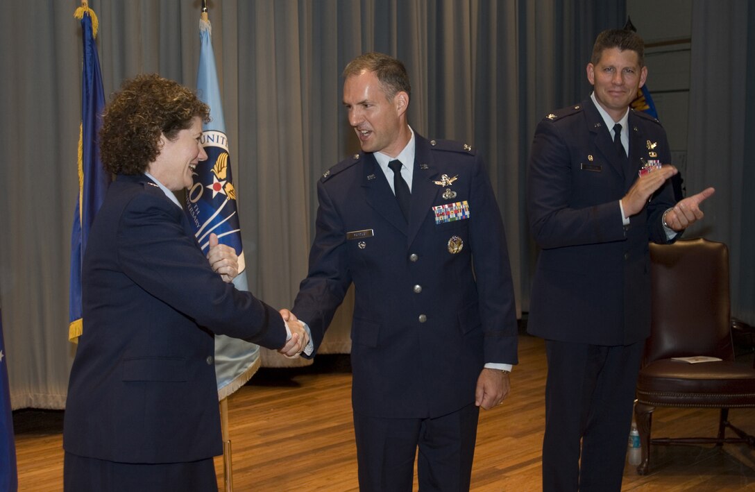 PATRICK AIR FORCE BASE, Fla. -- Brig. Gen. Susan Helms, 45th Space Wing commander, congratulates 45th Operations Group Commander Col. Bernie Gruber upon his accepting command July 12, while Col. David Thompson, outgoing 45th OG commander, claps. (U.S. Air Force photo by Jim Laviska)