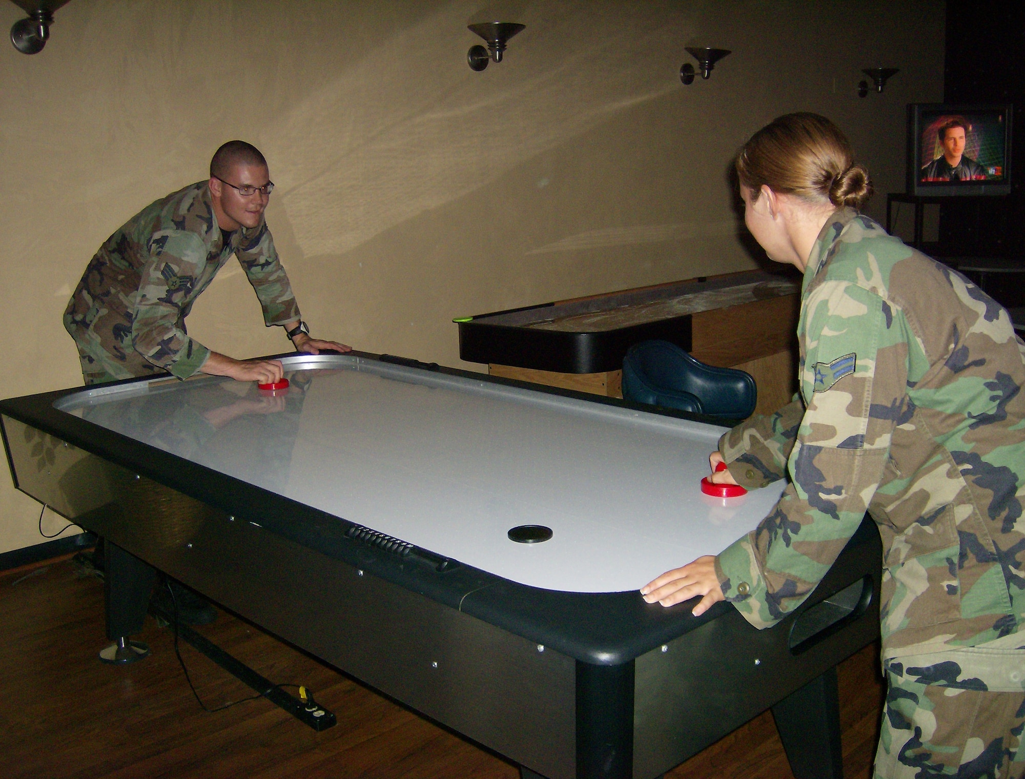 McGuire Airmen play air hockey at the community center game room here during an Ice Cream Social July 12. Team McGuire members were invited to enjoy ice cream, play games and socialize. 