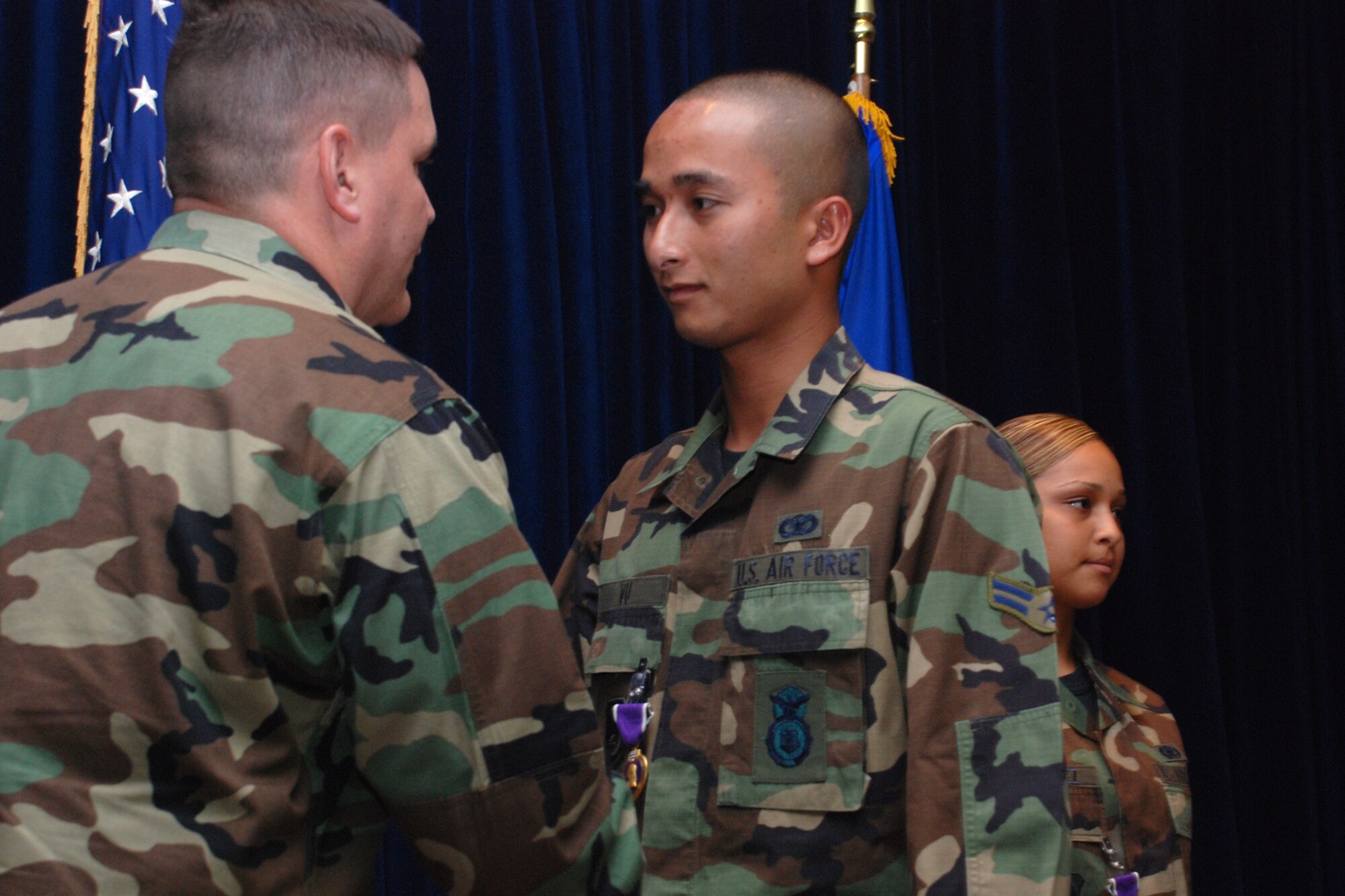 EGLIN AIR FORCE BASE, Fla. -- Airman 1st Class Andrew Vu, 96th Security Forces Squadron, receives a Purple Heart from Lt. Col. Timothy Meserve, squadron commander, for his injuries when the vehicle he was providing turret support for in Iraq was hit by an explosive device Jan. 20. The Airmen were part of a team due to fill a more traditional billet at a forward-operating base in Mosul, Iraq, but were redirected to Contingency Operating Base Speicher instead, taking on the in-lieu-of mission -- ordinarily tasked to the Army -- of training Iraqi police. The 15-member security forces team was awarded a U.S. Army Commendation Medal. (U.S. Air Force photo by Staff Sgt. Mike Meares)